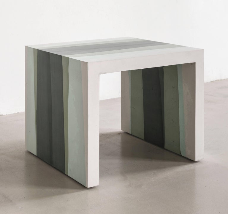 A contrast of softness and sharp angles, the made-to-order side table is cast entirely from hand-dyed cement. Poured in layers, the simple geometric form creates a light ombre effect reminiscent of watercolor. The piece weighs approximately 65lbs.