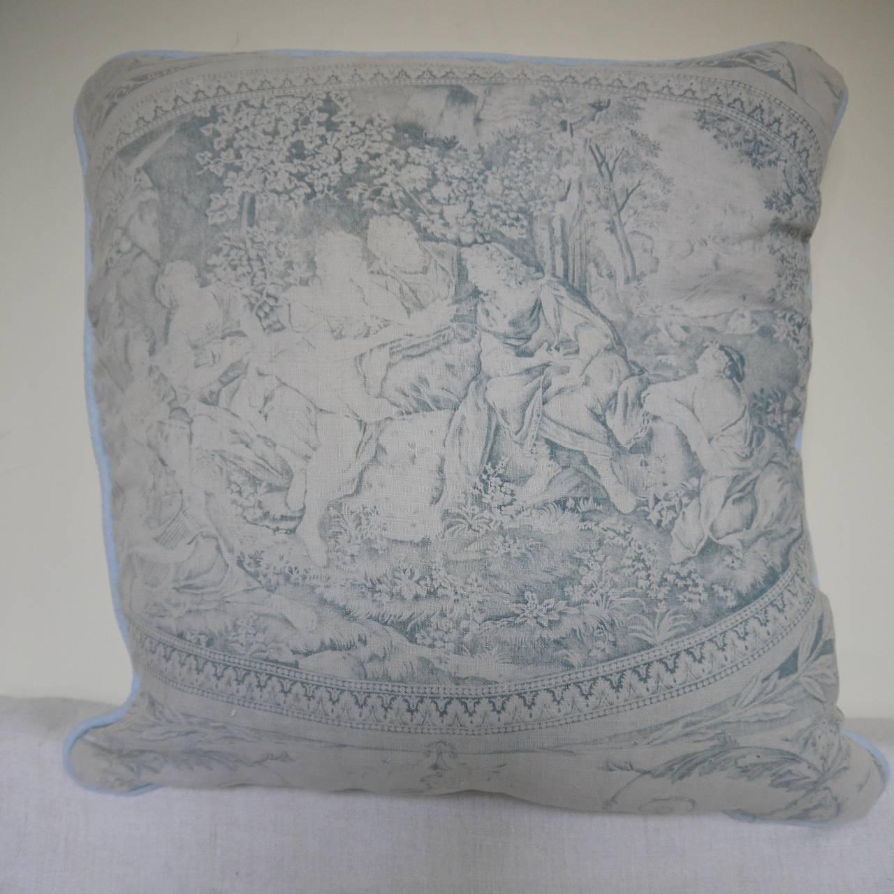 Later 19th century French and very prettily faded blue toile cushion. The design is a large-scale version of a circa 1790 Toile de Nantes called 'Telemaque et Calypso'. Backed in another section of the same design and piped in a pale blue linen.