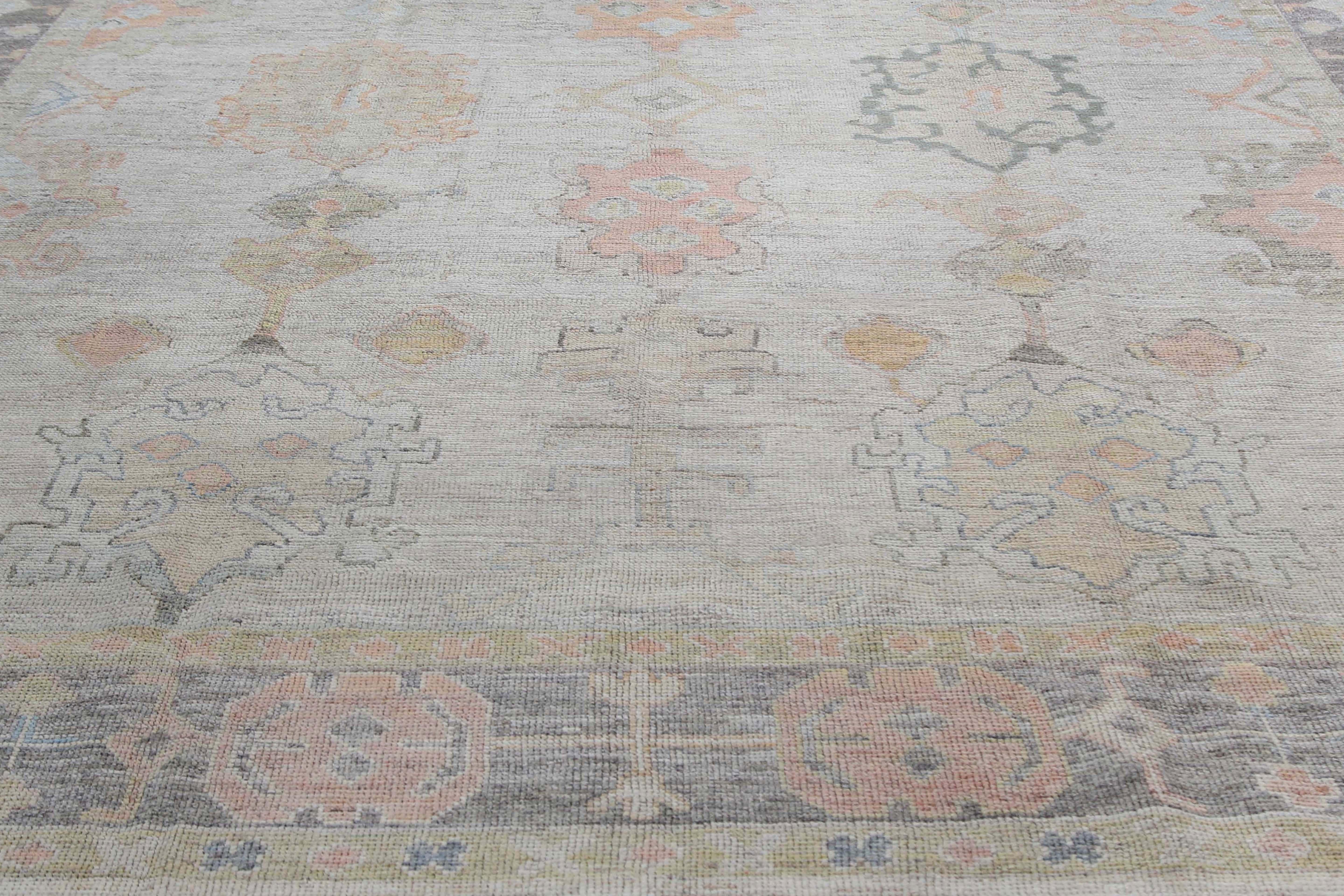 Introducing our exquisite handmade Turkish Oushak rug with a unique faded worn-down look. This rug features a defined border with a light green-grey background and a beautiful traditional design. The design incorporates various colors such as dark