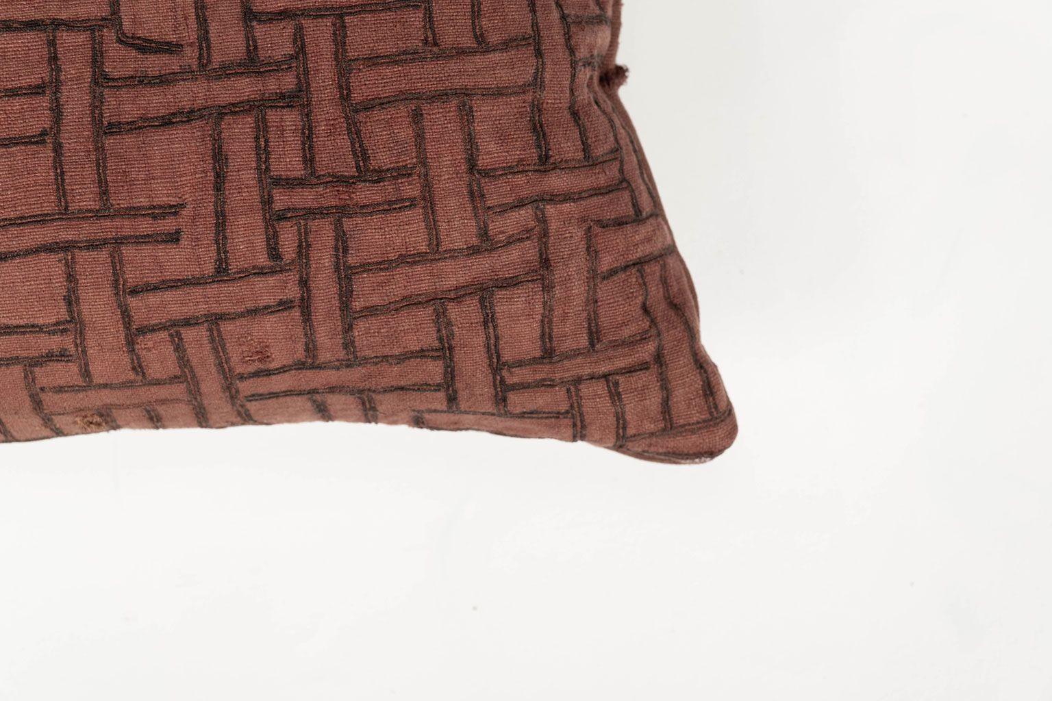 Coussin lombaire brodé de couleur prune délavée, fabriqué à partir d'un ancien textile tribal en coton tissé et teint à la main (vers 1930-1954). Cousu à la main, il constitue un magnifique oreiller à dos libre, avec fermeture éclair et garniture en