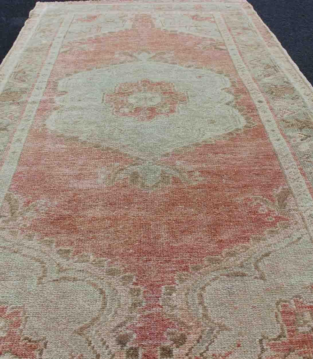 Wool Faded Red and Taupe Vintage Turkish Oushak Rug with Layered Medallion Design For Sale