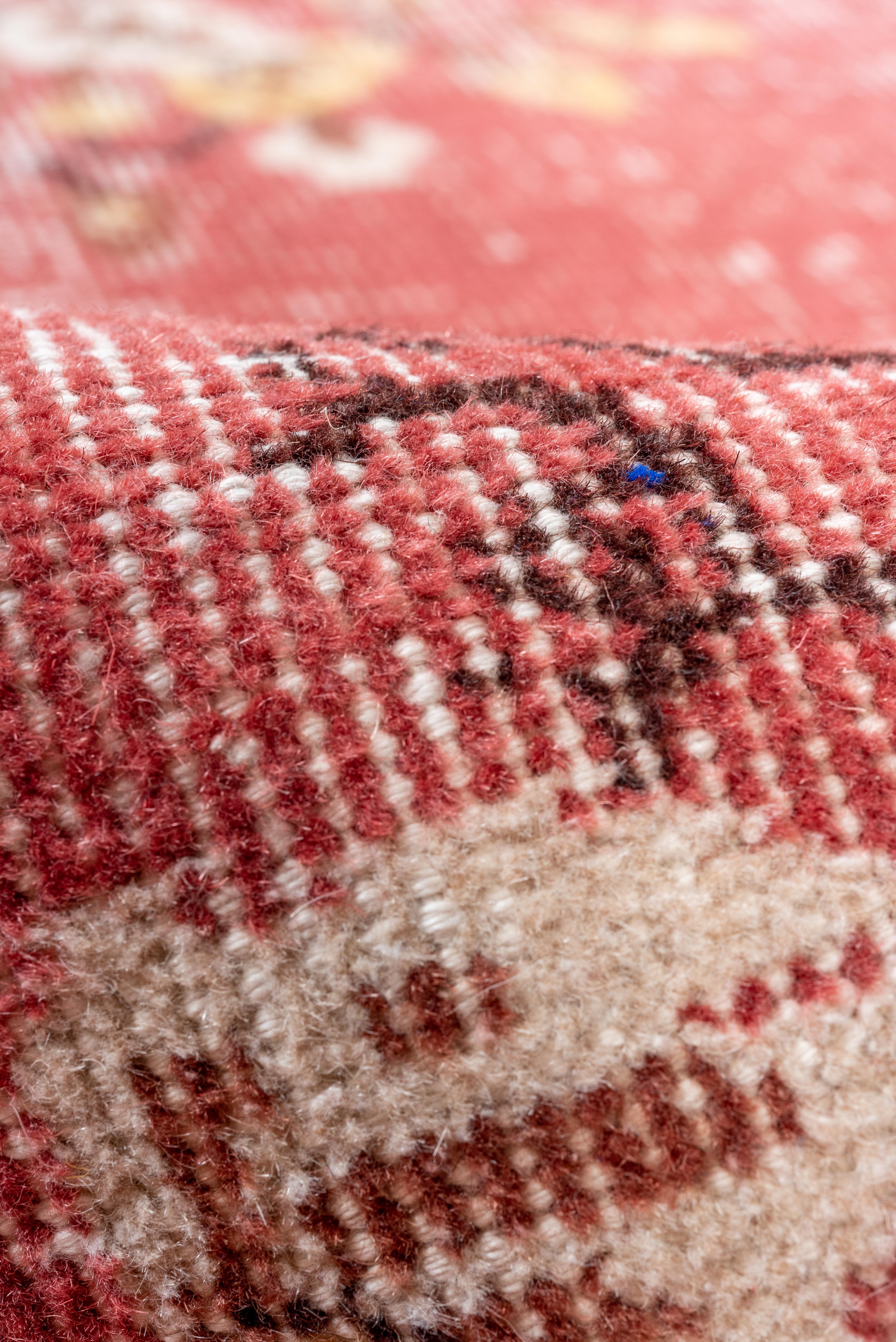 Dieser bezaubernde Läufer aus Oushak im Vintage-Stil hat einen wunderschön gedämpften rosa Grund mit verstreuten elfenbeinfarbenen und erröteten Blumenmedaillons. Die handgeknüpfte Textur verleiht ihm eine anmutige Patina, die seine Farbpalette in