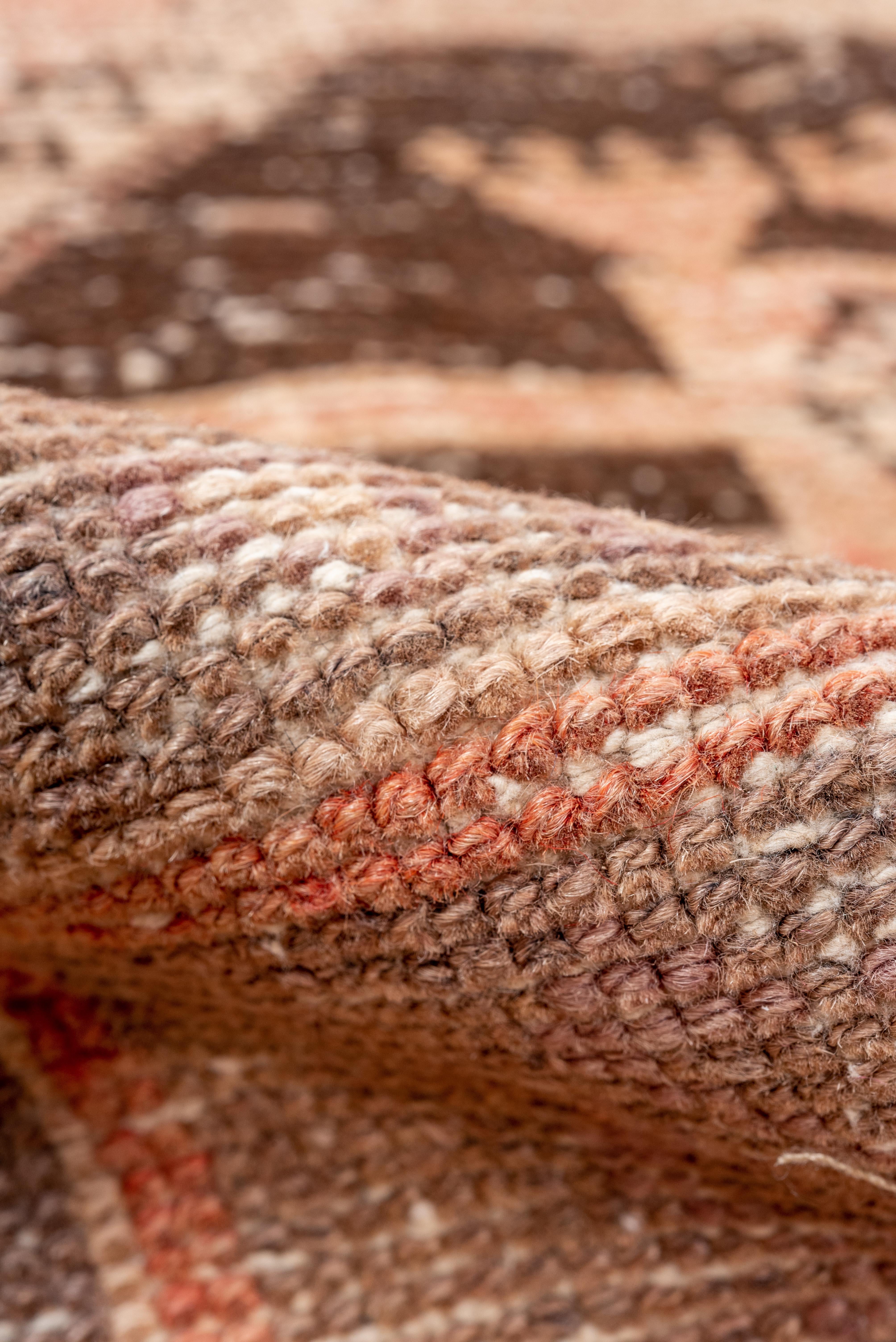 Dieser im Vintage-Stil gewaschene Oushak-Läufer verbindet rustikalen Charme mit raffinierter Raffinesse. Die Palette des Teppichs mit seinen großflächigen, geometrischen Medaillons reicht von sonnenverblasstem Terrakotta über sanftes Beige bis hin