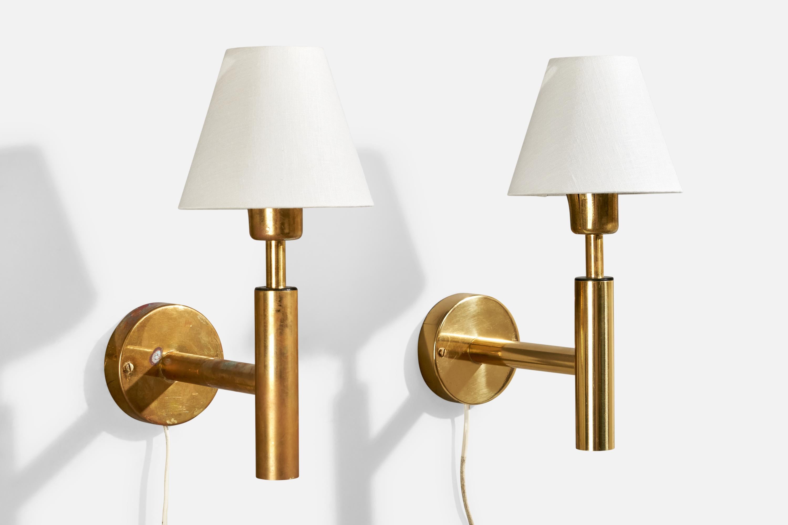 A pair of brass and white fabric wall lights produced by Fagerhults Belysning, Sweden, c. 1960s.

Sold with Lampshades.

Dimensions stated are of wall light with Shade.

Dimensions of back plate (inches) : (4.12 x 4.12 x 1) (H x W x D)

All lighting