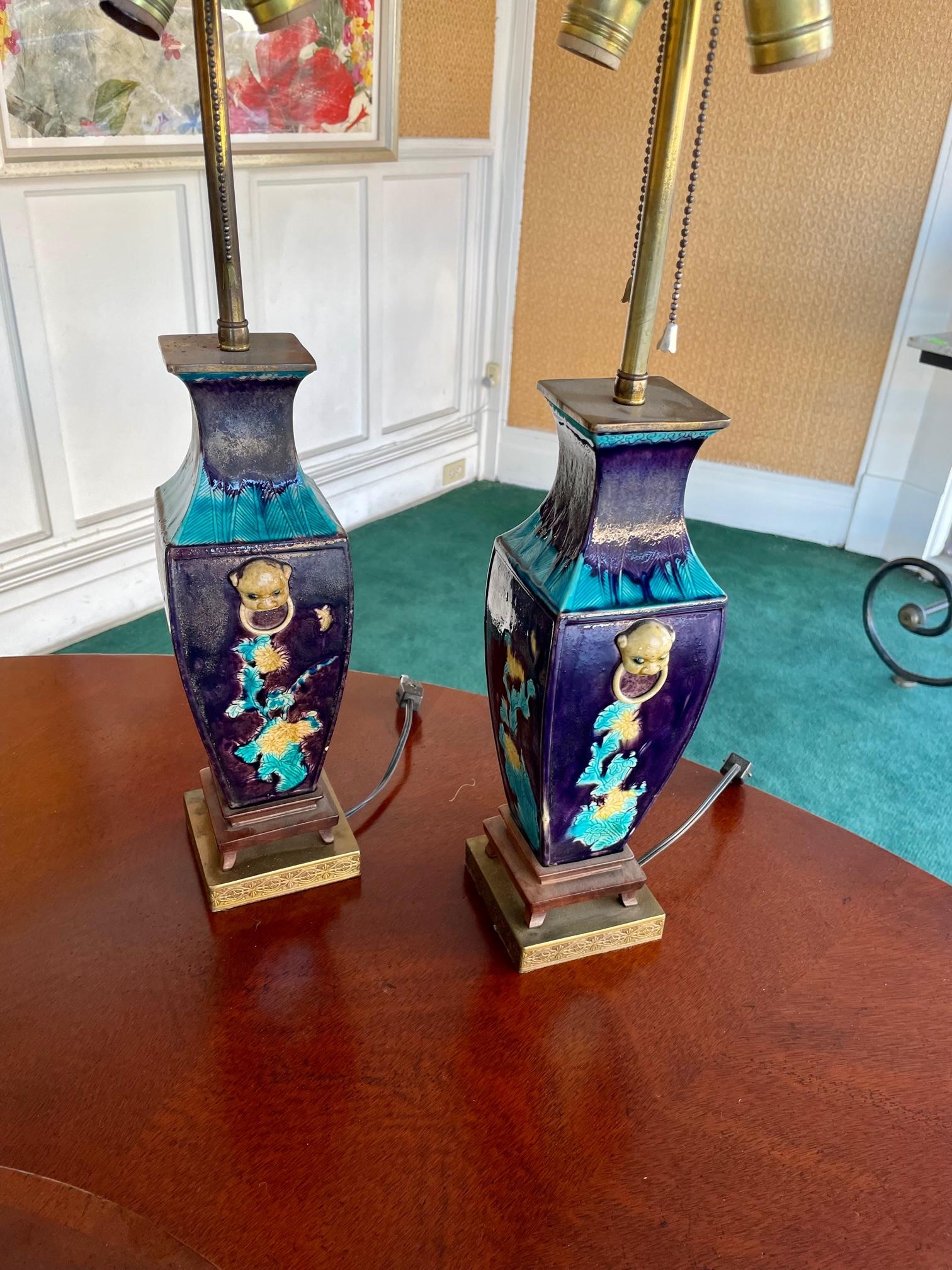 Pair of Fahua-style glazed porcelain vases, late 19th century; mounted and electrified as lamps, on simple teak stands and mounted on incised brass plinth bases; including custom yellow silk box pleat shades. Fahua refers to Chinese style ware