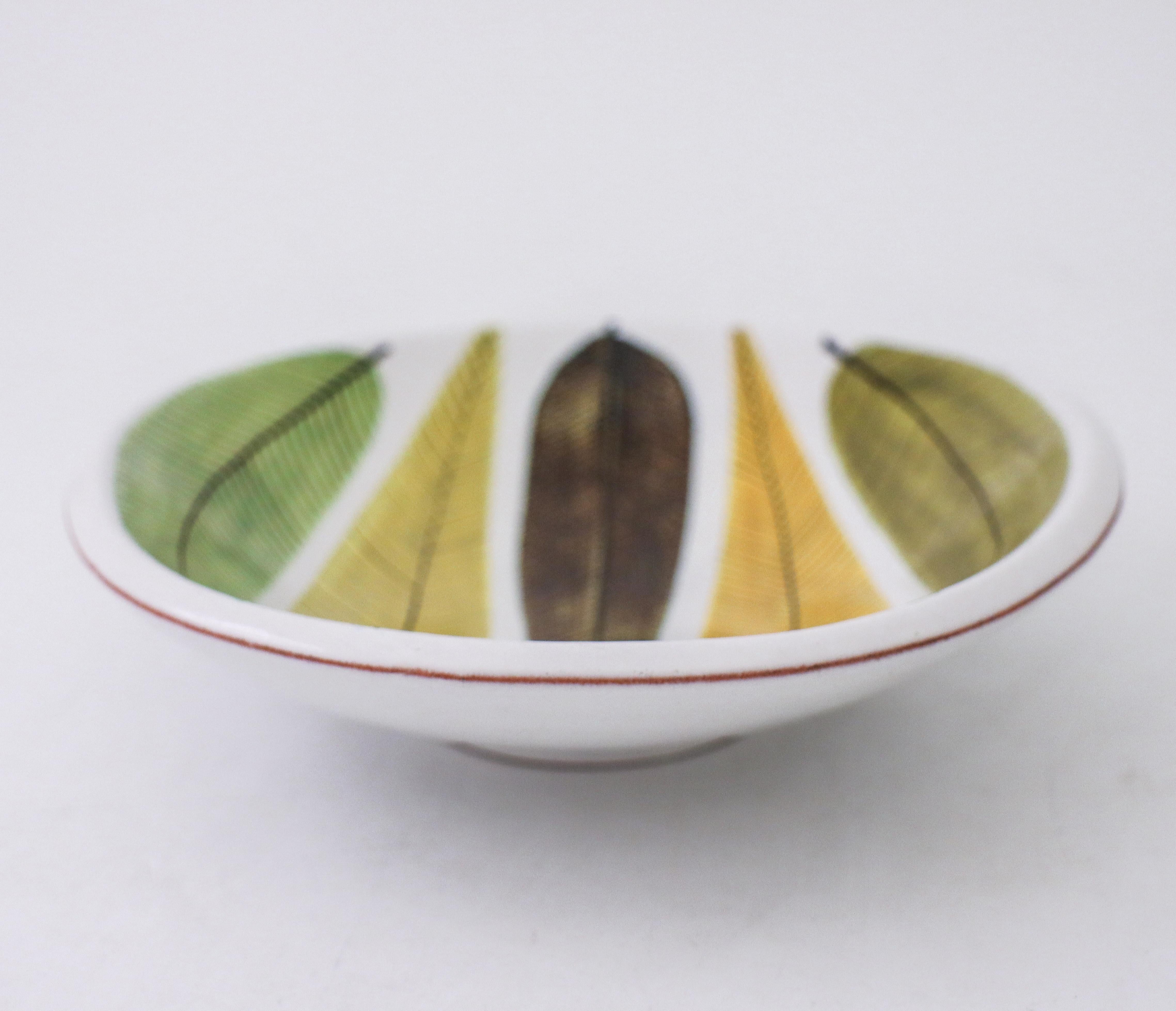A round bowl in faience designed by Stig Lindberg at Gustavsberg Studio with a lovely decor of leafs, it´s 20,5 x 18,5 cm (8,2