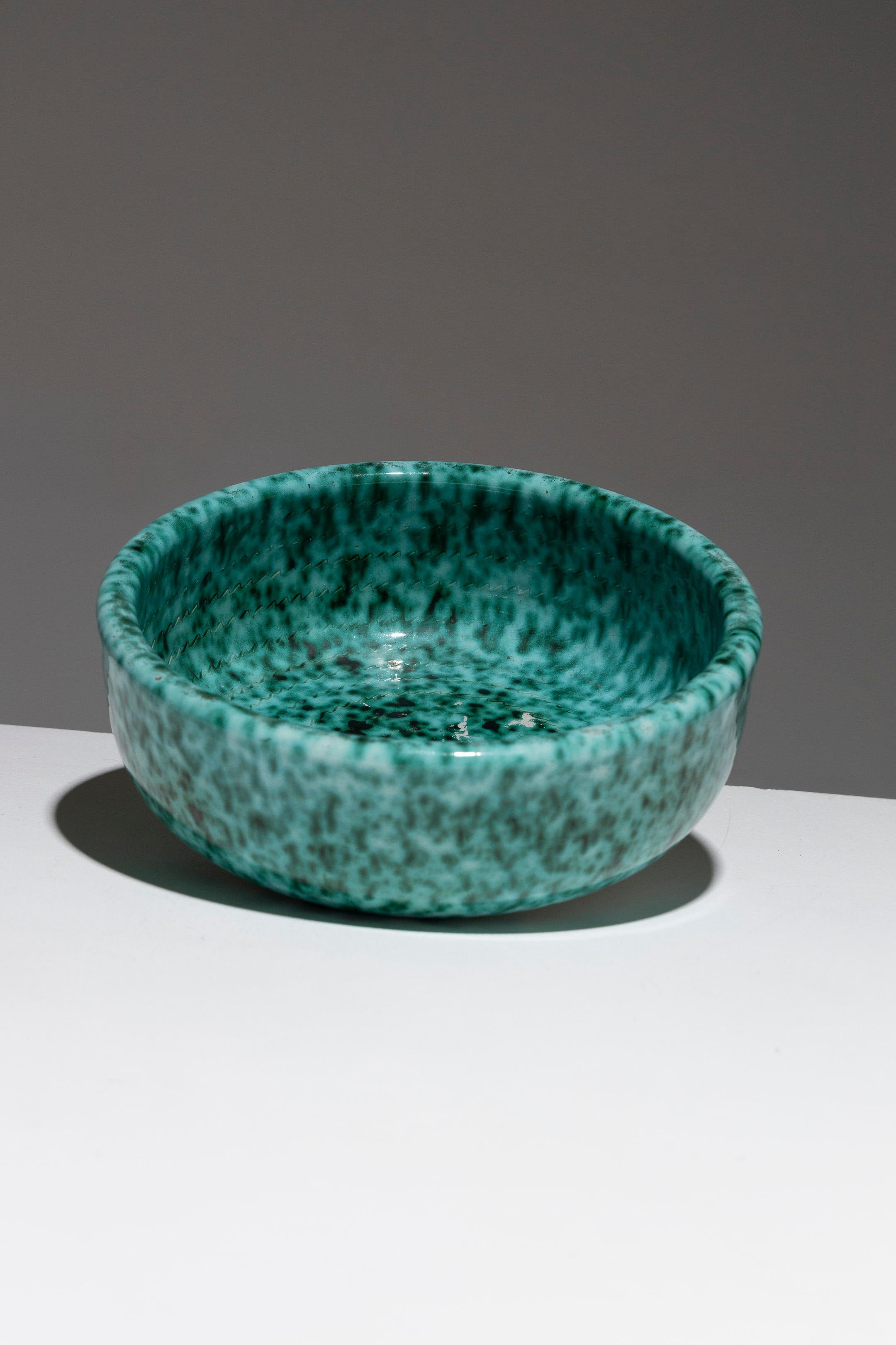 Ciotola in faience con bordo alto di Fernand Elchinger, anni '50. Lo smalto verde rame scuro è punteggiato di bianco e all'interno è inciso un motivo a nastro. Marchio stampato sotto la base: 'Céramique d'Art / Elchinger Fils / ....'. Condizioni