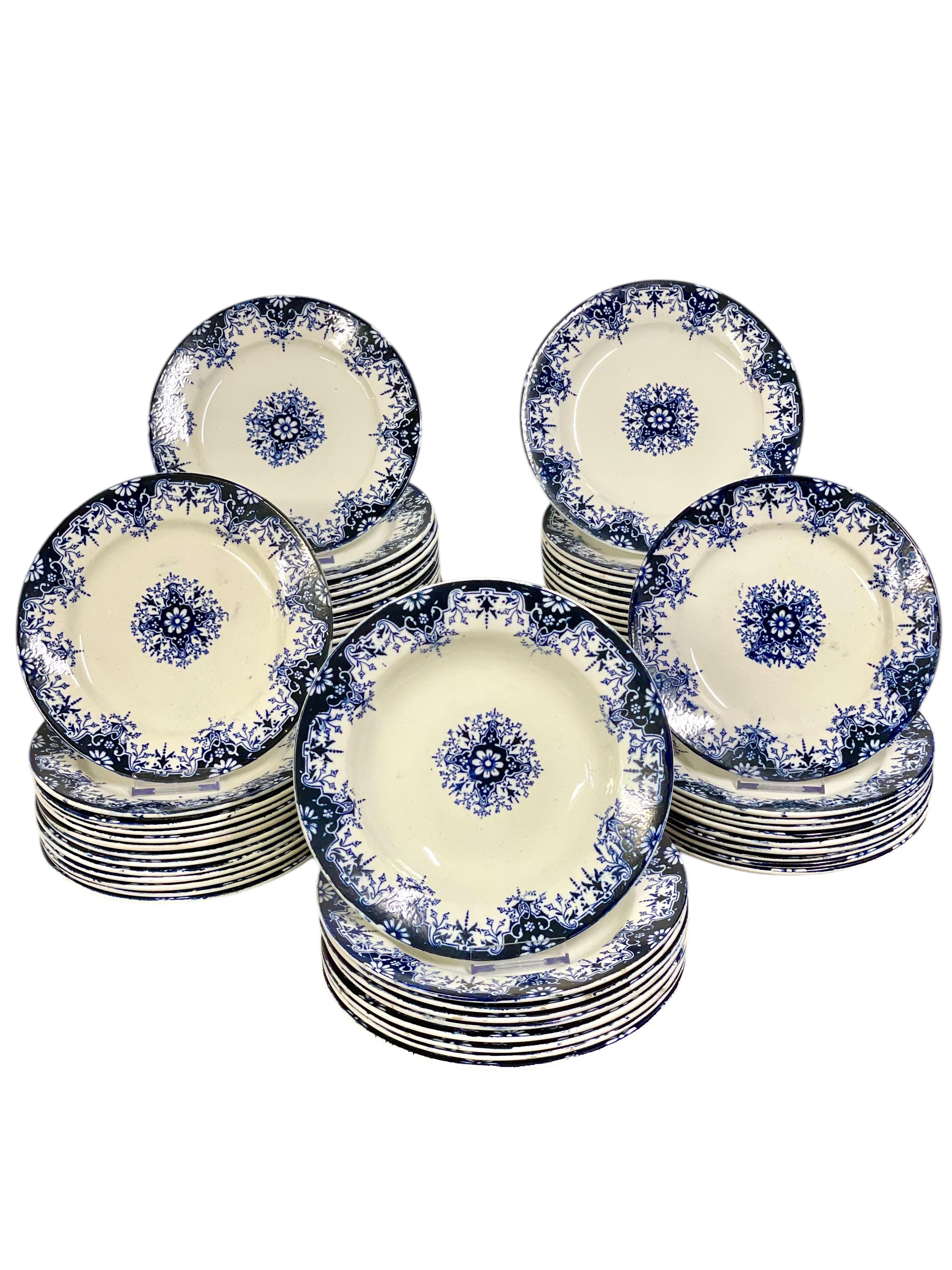 Lleva la elegancia francesa atemporal a tu mesa con esta exquisita vajilla de loza antigua de 75 piezas, bellamente adornada con motivos florales pintados a mano en azul cobalto intenso sobre un cálido fondo marfil. Este conjunto, que data de