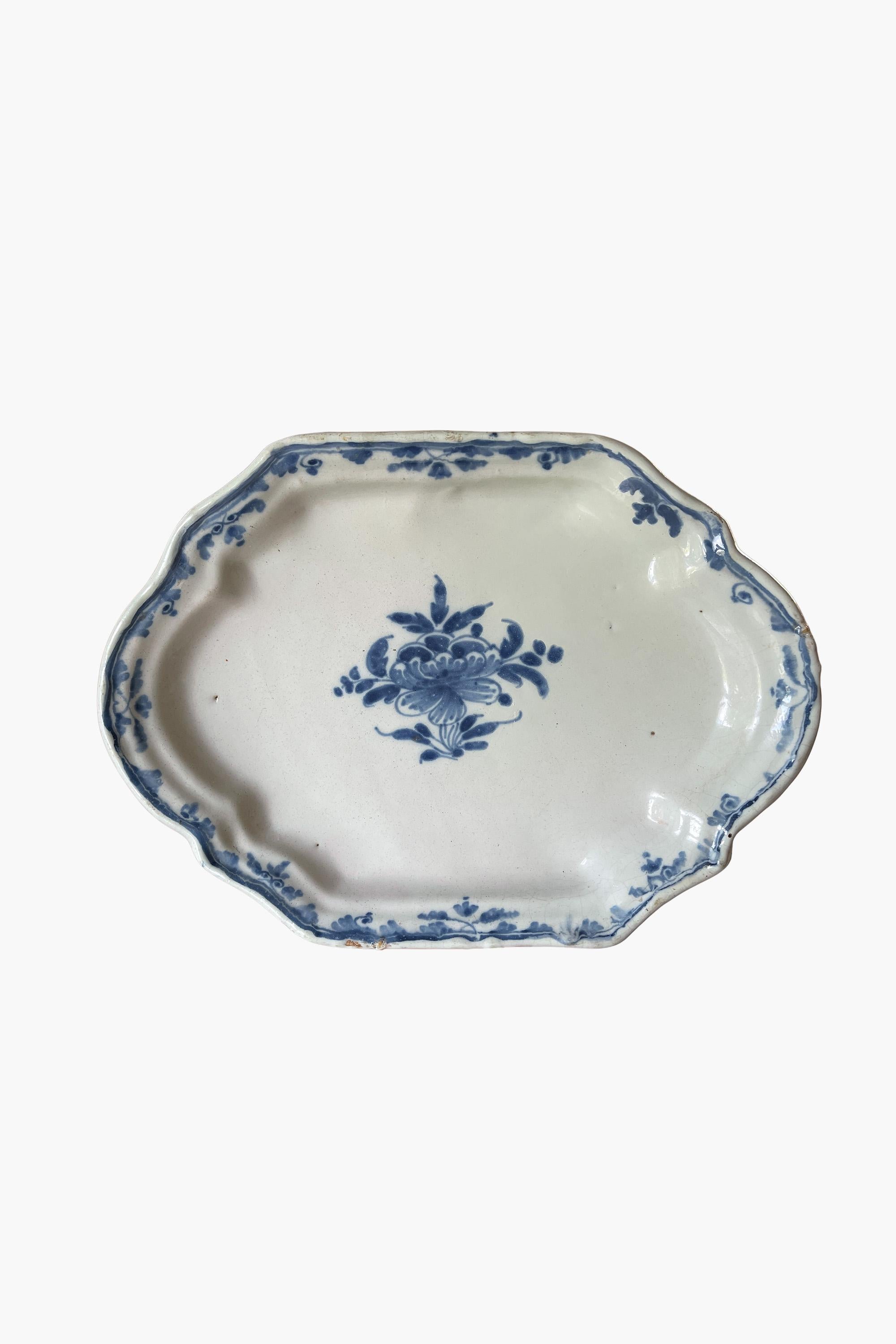 Early 18th century rouen faience dish

An early 18th-century blue and white faience dish from Rouen. Decorated with a central basket of flowers, surrounded by a border of scrolling leaves.

The thick white glaze and painterly decoration in blue