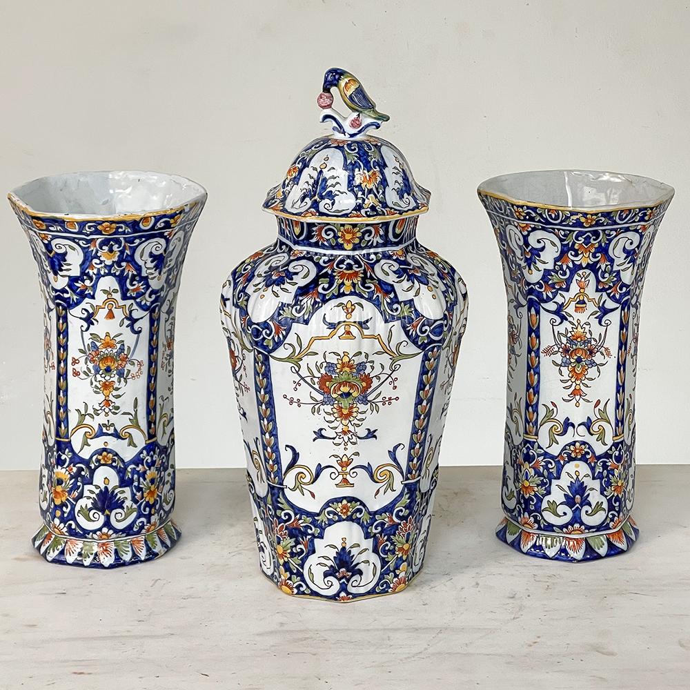 Faience Garniture from Rouen ~ Pair of Ceramic vases with matching Lidded Urn was entirely hand-painted by talented artists in a classical theme using vibrant cobalt blues, mustard yellows and olive greens creating intricate scenes of flowers and