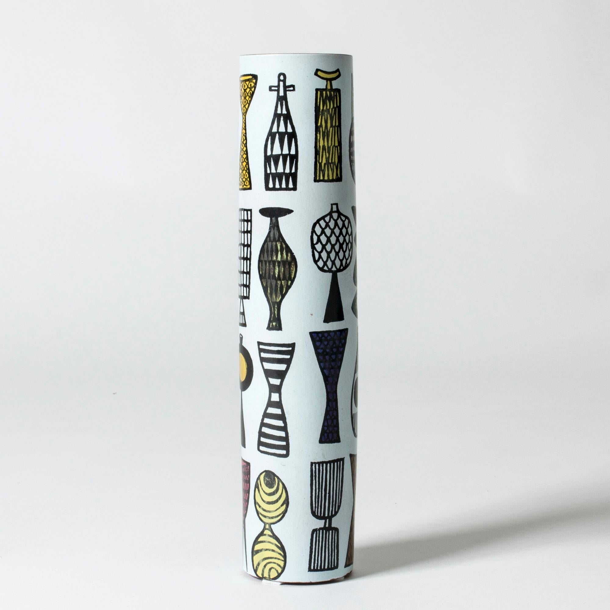 Faience “Karneval” vase by Stig Lindberg, in a long cylinder shape. Rare motif with a graphic look, of playful vases in different forms. The rim is unglazed, giving an organic touch to the smooth design.

The “Karneval” series was produced from
