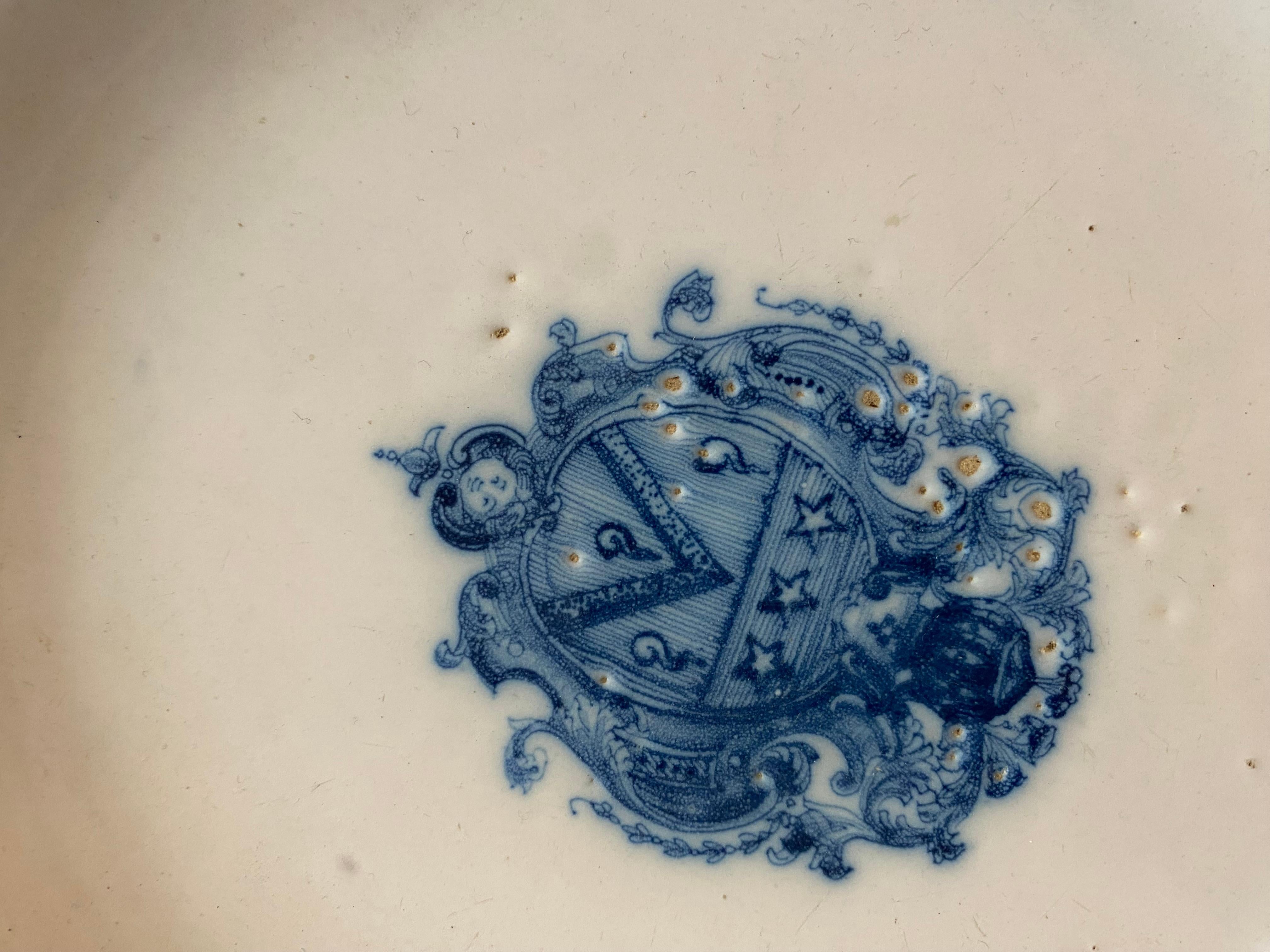 Very pretty 18th century Moustier earthenware plate with central decoration of a coat of arms in blue monochrome. The scalloped edge is decorated with a “Bérain” frieze. Perfect condition except for a few slight cooking bubbles.