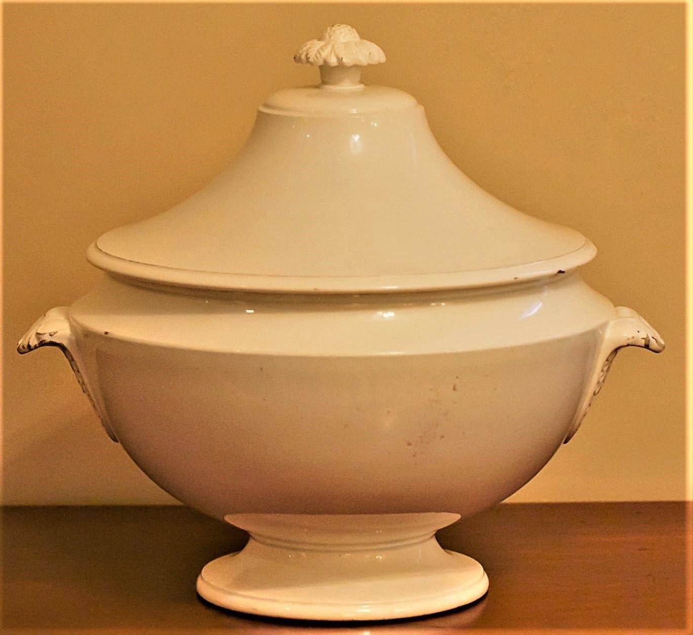 This round off-white soft-paste porcelain soup tureen was made by Paihart & Hautin in their suburban Paris factory.  The design is inspired by the Classical movement of the day. The handles and finial have impressed designs. There is an impressed