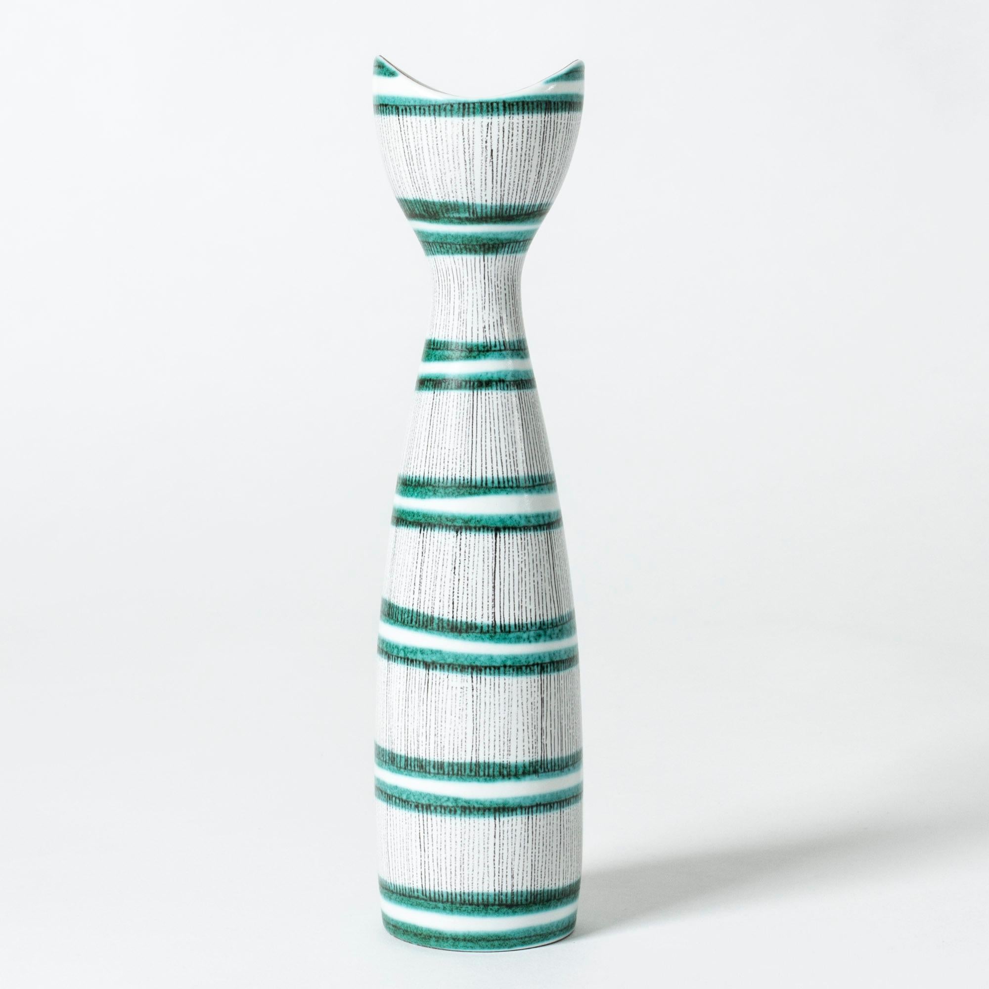 Cool faience vase by Stig Lindberg, in a lively, fun form. Graphic pattern of black and green stripes, elegantly hand-painted.