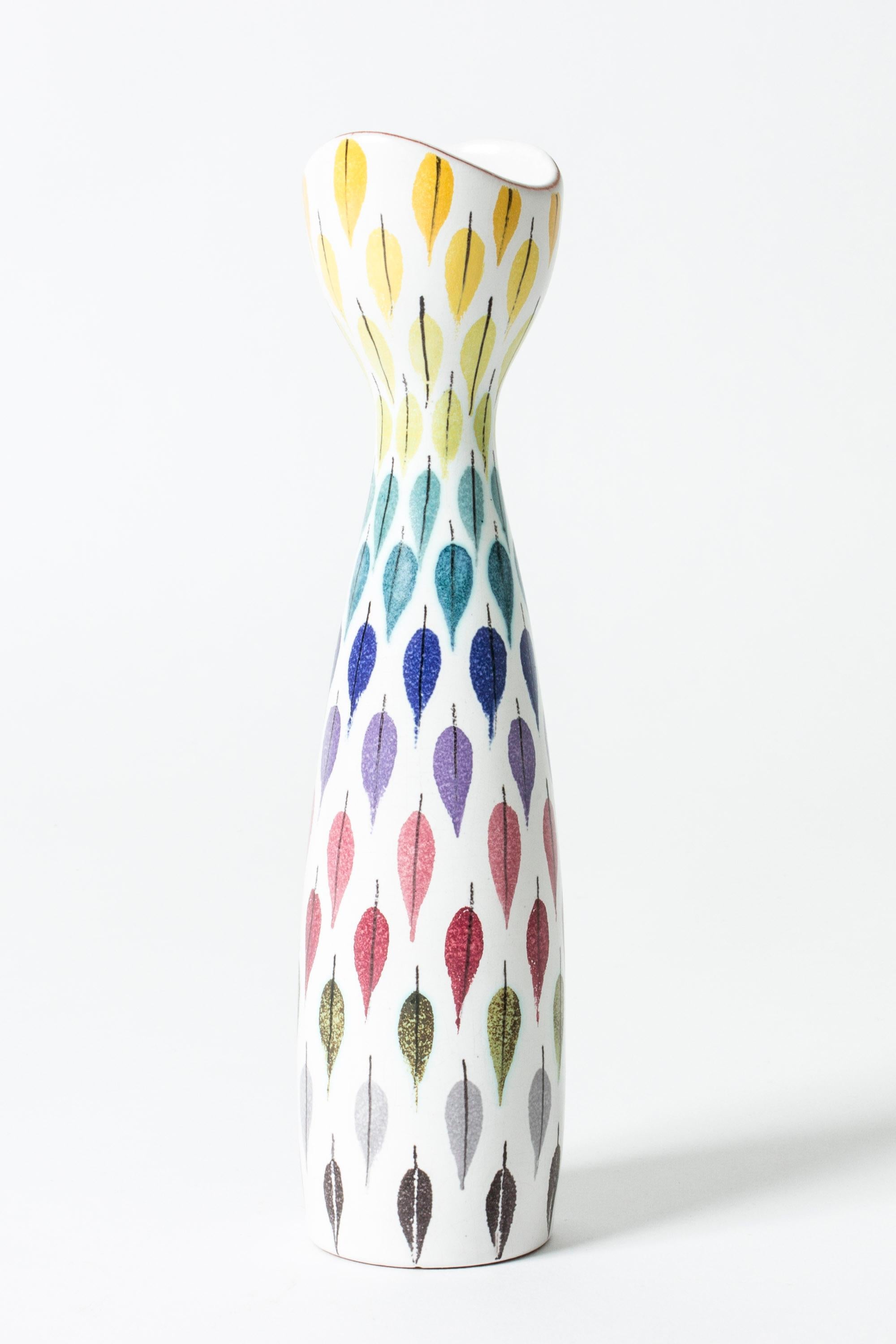Faience vase by Stig Lindberg in a slender, curved form. Beautiful decor of leaves in vibrant colors.