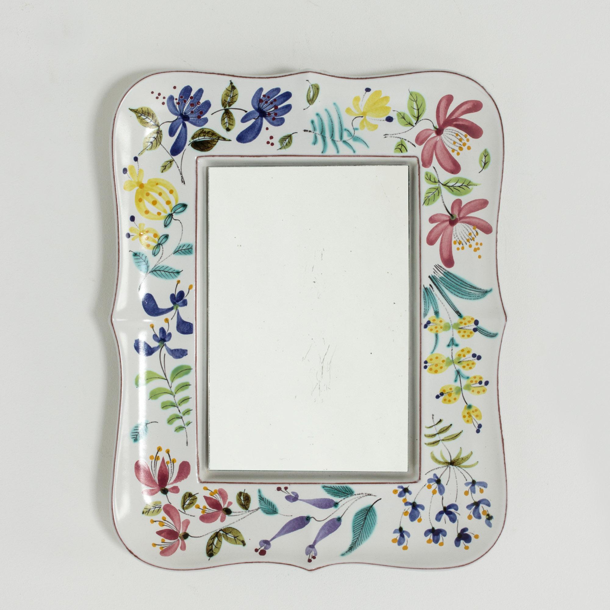 Beautiful faience wall mirror by Stig Lindberg with a vivacious, colorful decor of flowers and leaves.