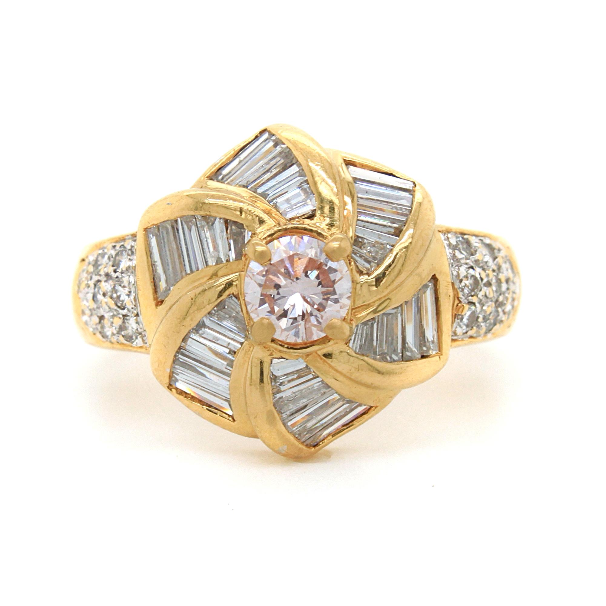 A pink and white diamond ring in 18k yellow gold. The centre stone weighs approximately 0.4 carats and has a faint pink natural colour and SI1 clarity (not eye visible). It is surround by diamond baguettes in a windmill design and round brilliant