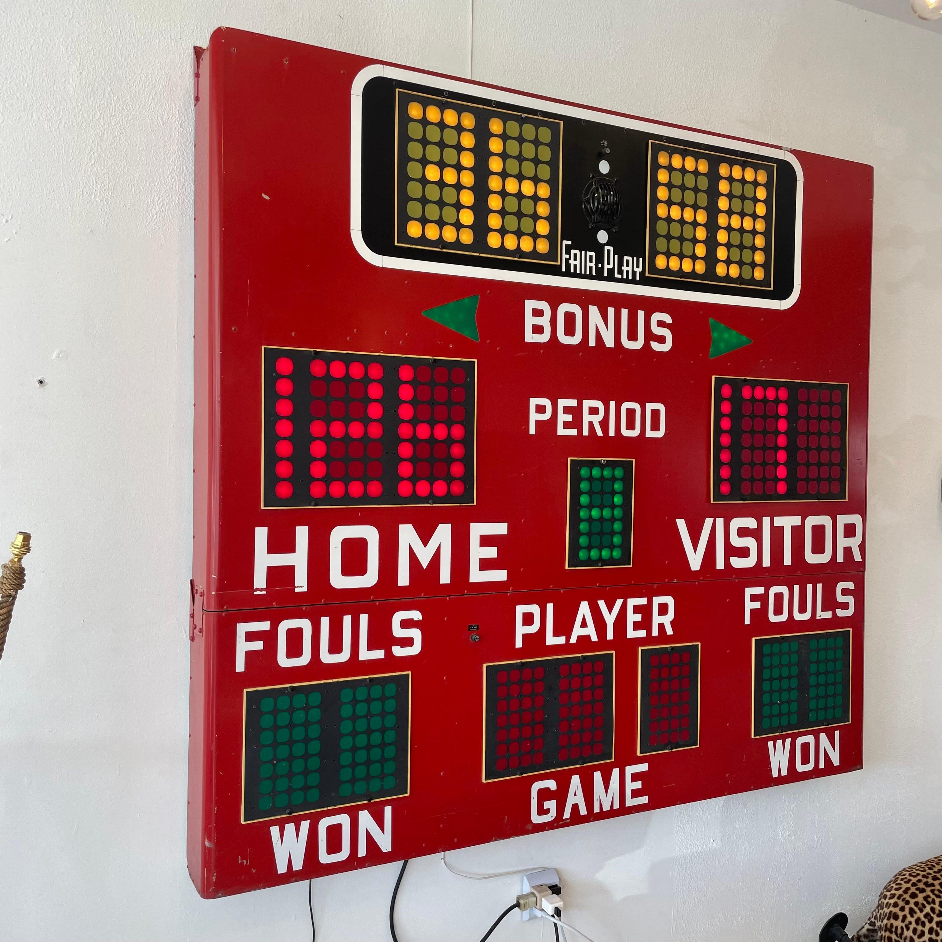 Vintage basketball scoreboard by Fair Play, made in the 1980s. Taken down from Lowry Air Force base, a military base with a lot of history. In full working order with controller to adjust score, running shot clock, and working horn.  Red metal case