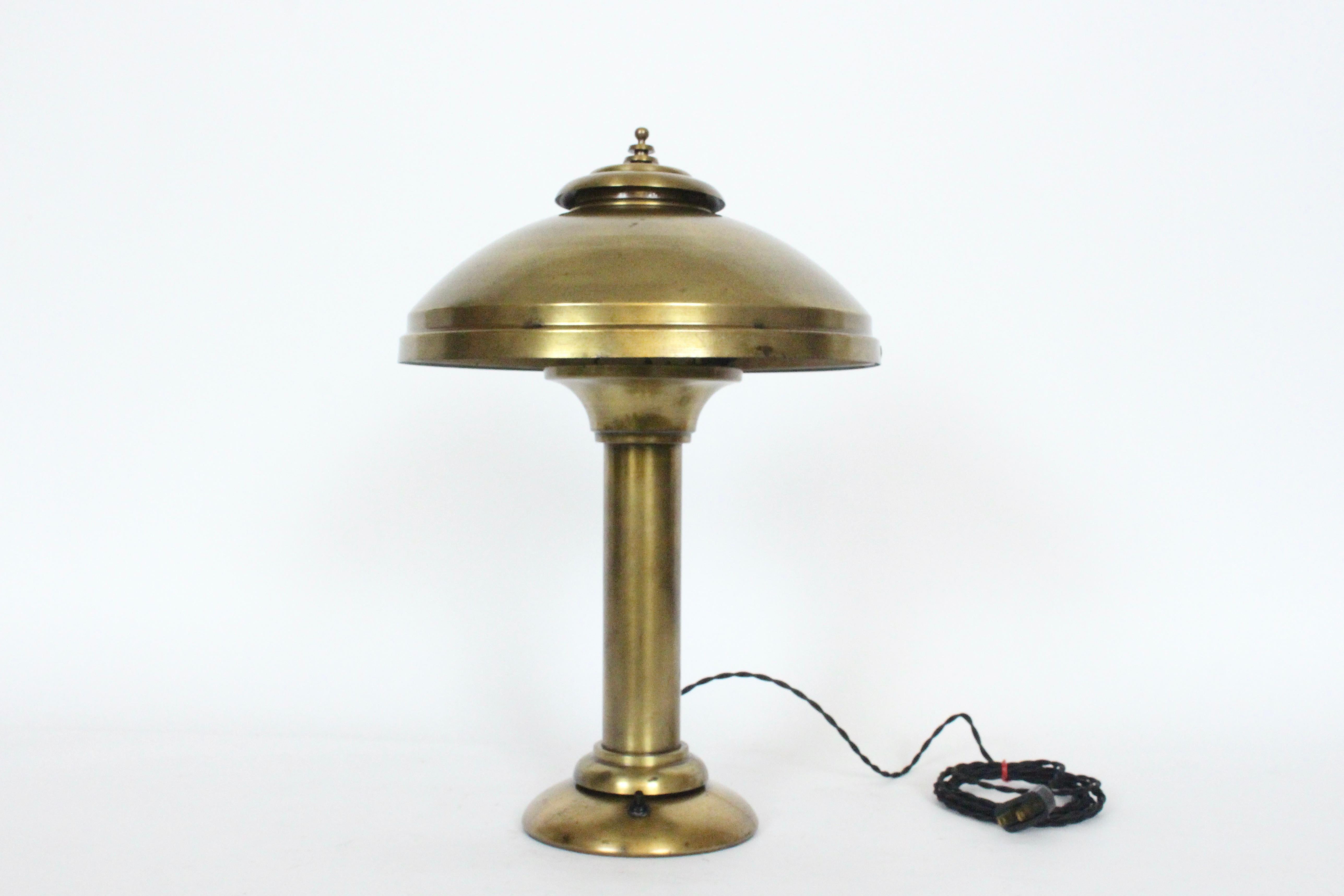 Late Art Deco Fairies Manufacturing Company brass desk lamp, table lamp circa 1920s. Featuring an overall yellow brass finish, wide cylinder stem with flared top, pivoting cantilever vented dome Hood (11D x 5D), atop a rounded weighted base. Tilts