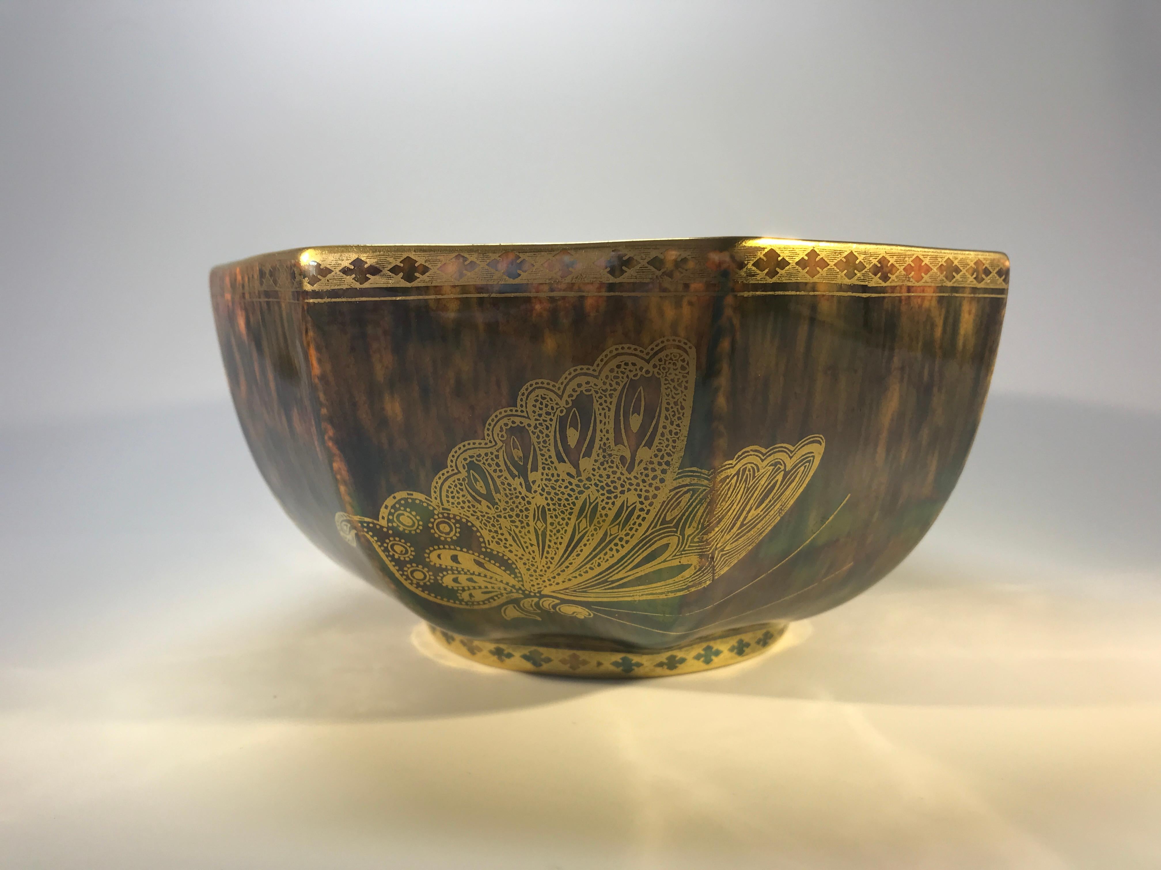 Daisy Makeig-Jones for Wedgwood, England octagonal bone china bowl with the interior decorated with mother of pearl colored mottlings and three richly decorated butterflies. Exterior is embellished with large gilt butterflies on a rich bronze