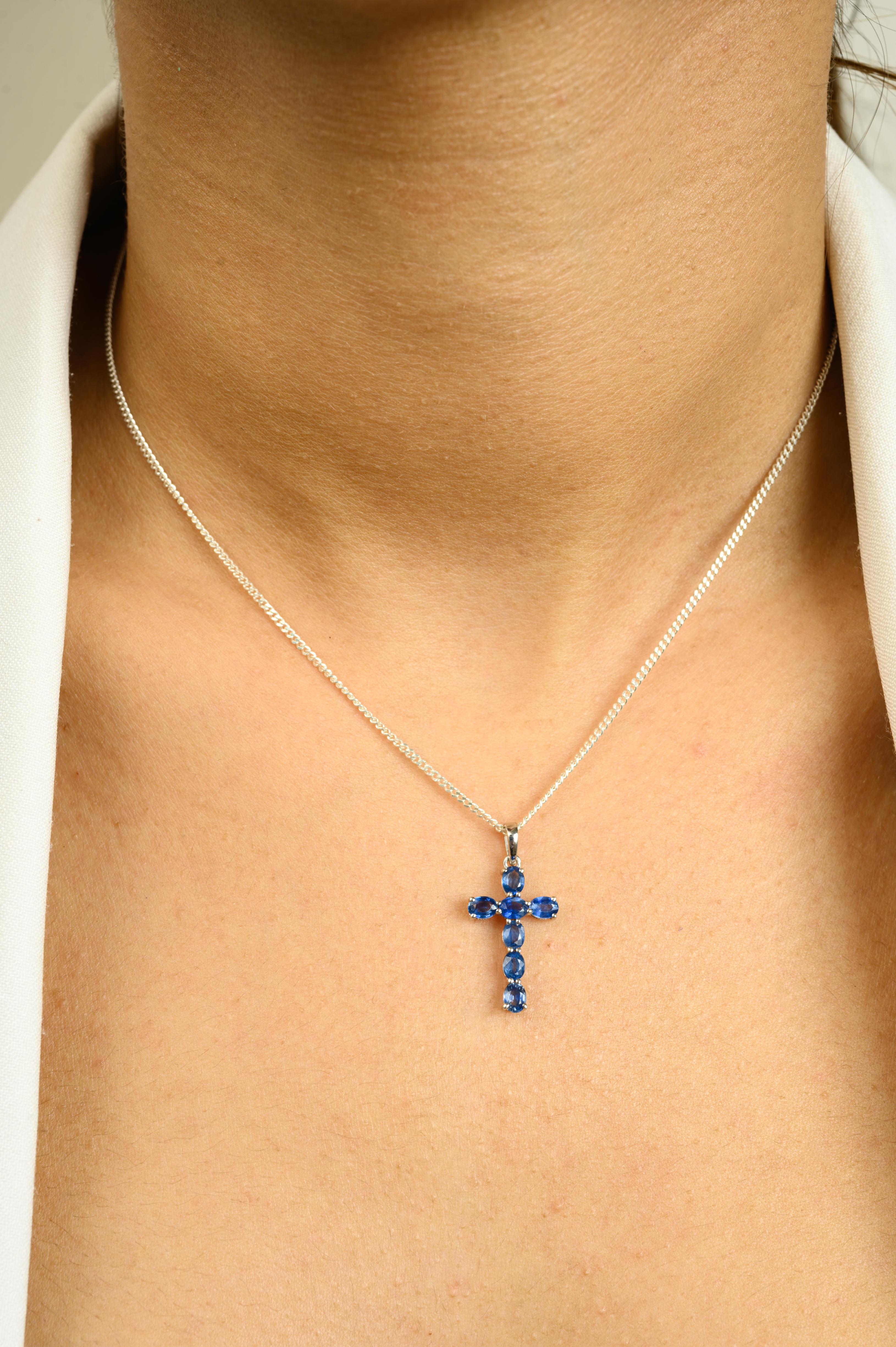 Elevate your style with this stunning 14 Karat Solid White Gold Cross Pendant with Blue Sapphire Accent, a perfect blend of faith and elegance. This exquisite piece features seven oval-cut natural blue sapphires, totaling 1.54 carats, set in a sleek