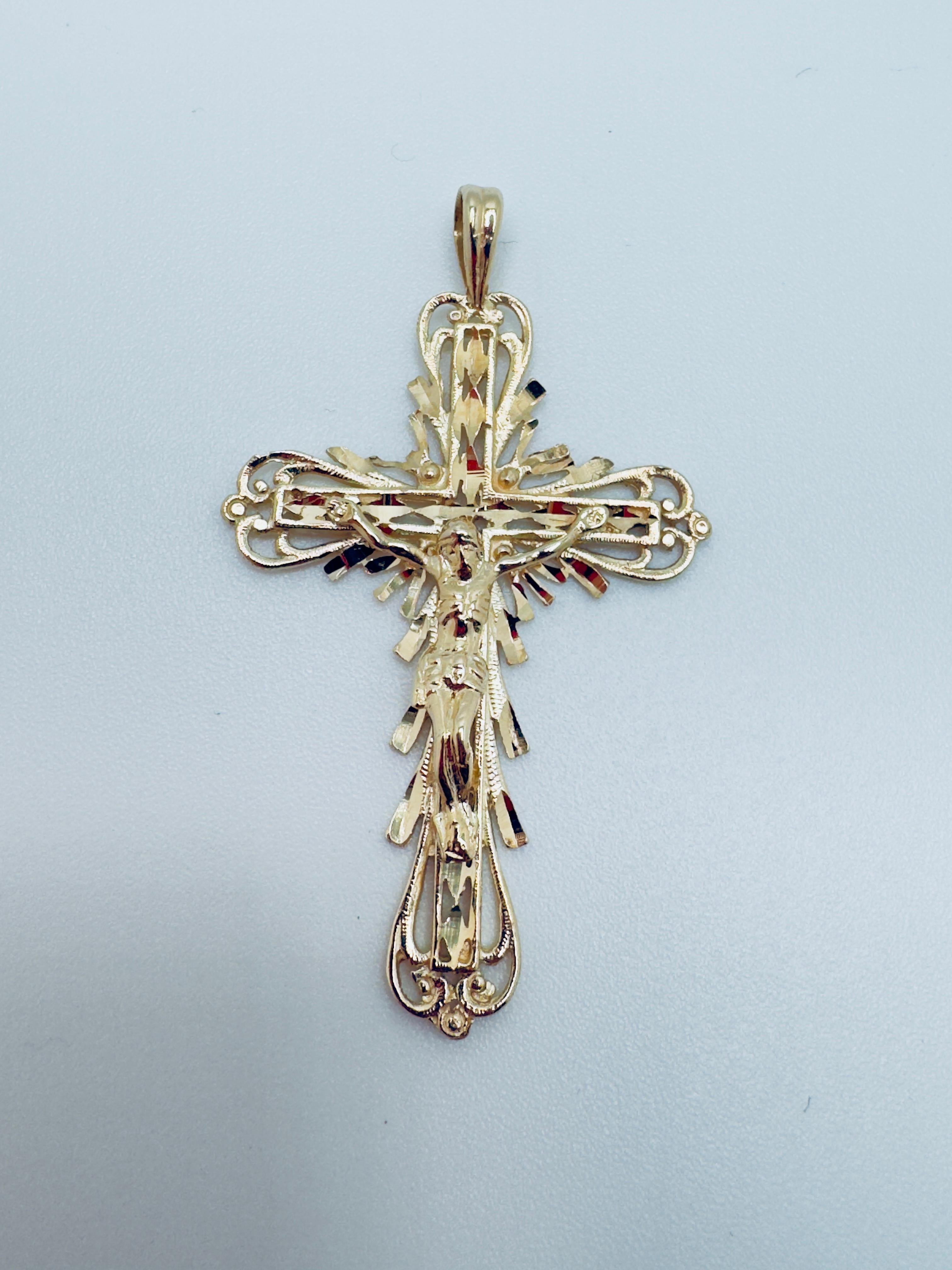 Questo ciondolo a forma di croce religiosa è splendidamente realizzato in oro giallo 14K e disegnato nell'elegante stile di F. Ligriee. Il pezzo presenta una raffinata finitura a taglio di diamante che ne esalta la brillantezza, catturando e