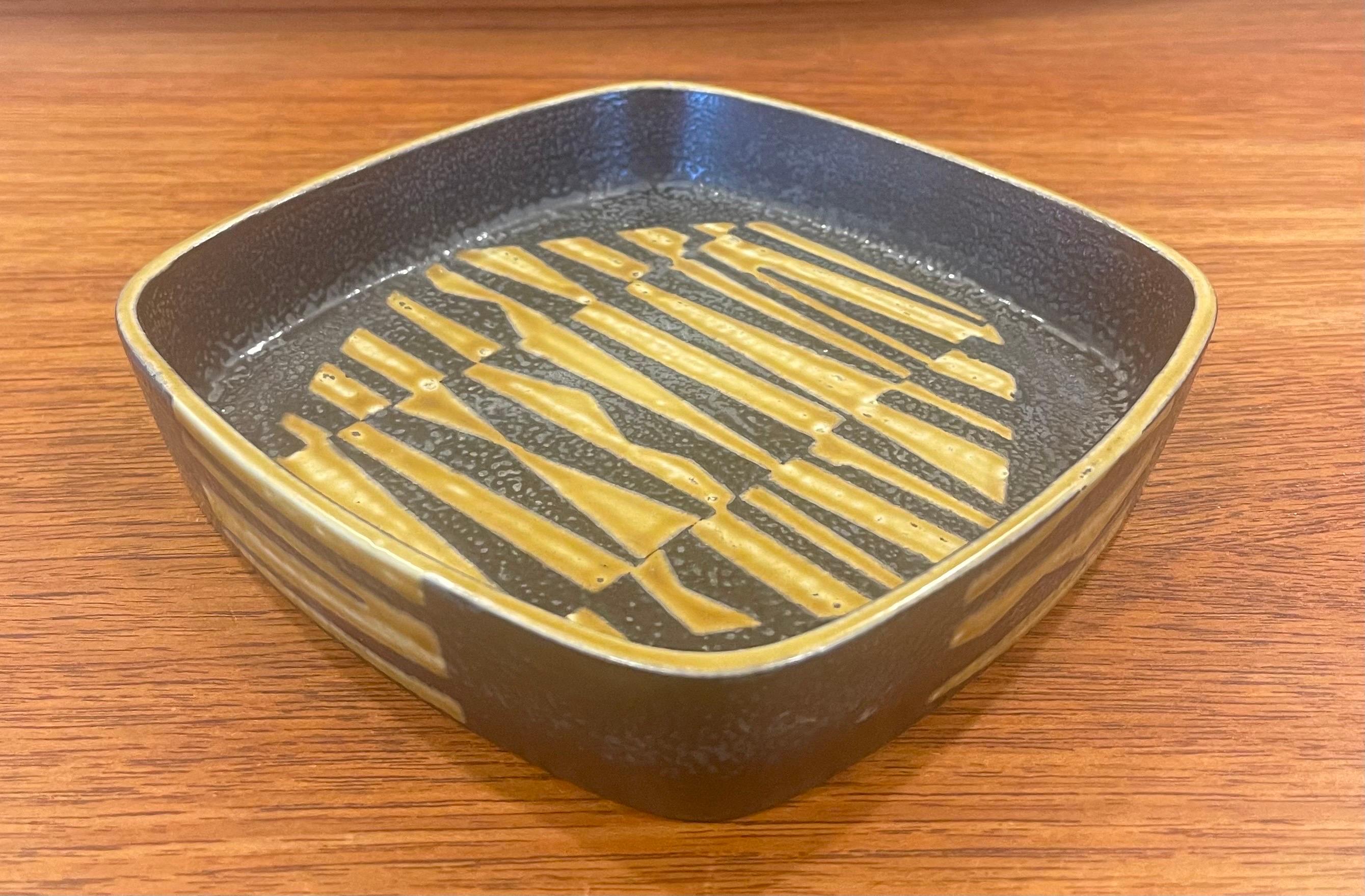 Wonderful Fajance square bowl from the Baca line by Nils Thorsson for Royal Copenhagen, circa 1960s. The stunning gold and brown glazed stoneware bowl with geometric abstract design was designed by Royal Copenhagen's renowned artistic director, Nils