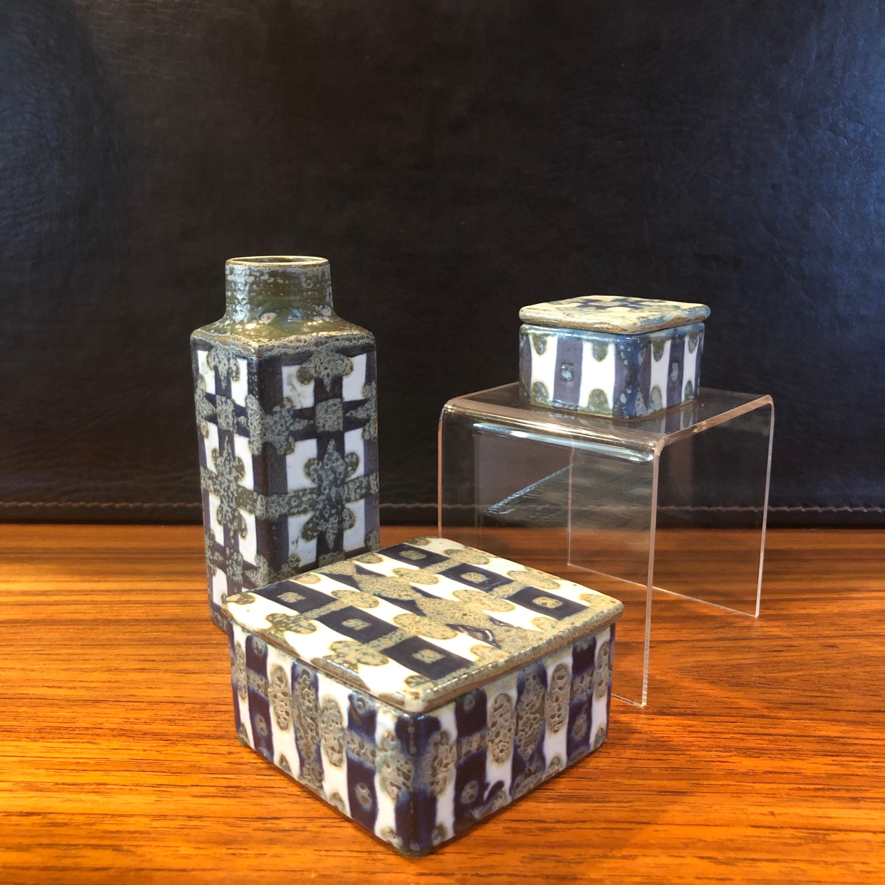 Wonderful Fajance three-piece vase and lidded box set from the Baca line by Nils Thorsson for Royal Copenhagen, circa 1960s. The grey, white and navy blue glazed stoneware containers with geometric abstract design was designed by Royal Copenhagen's