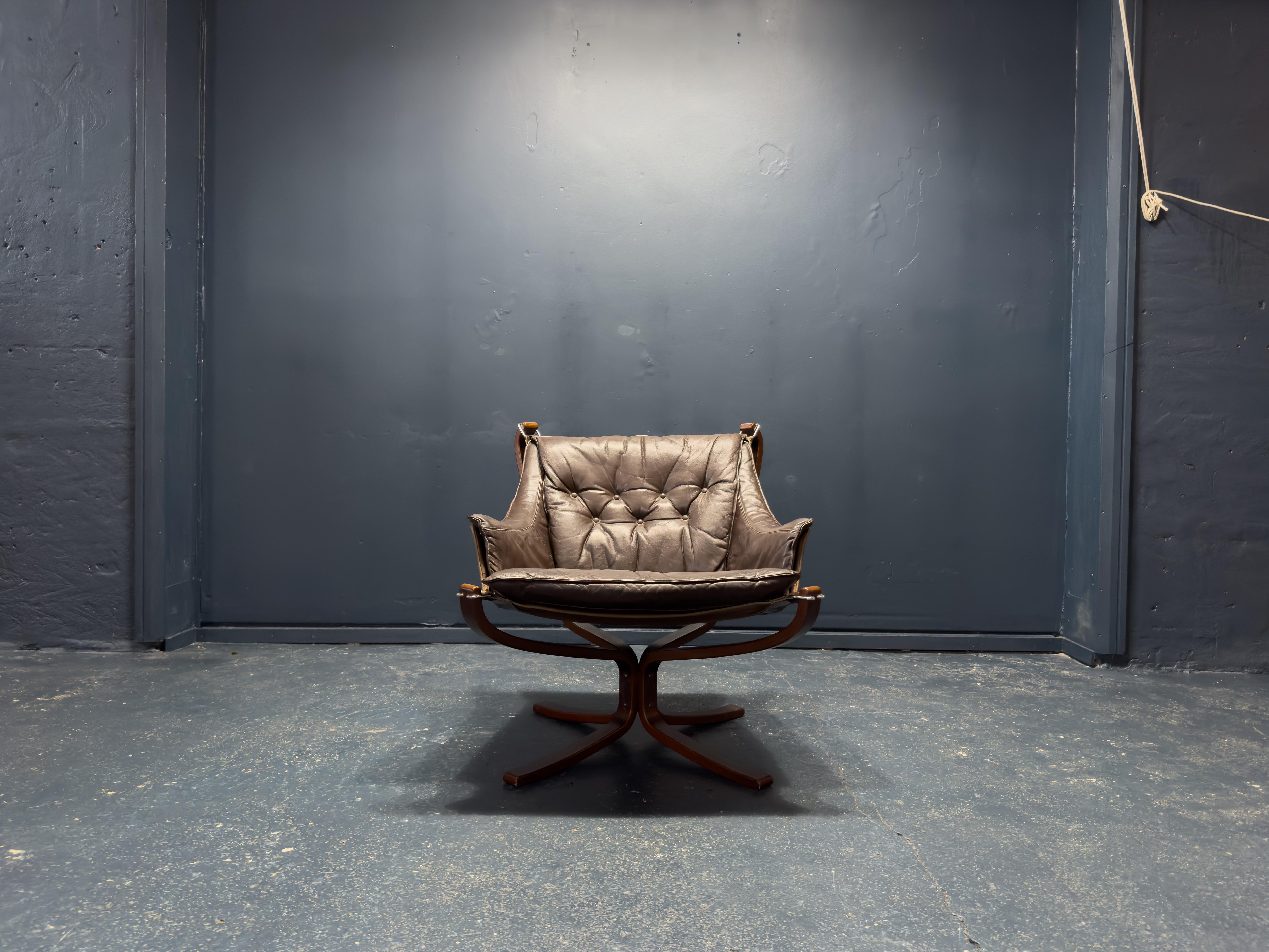 Iconic armchair designed by Norwegian designer Sigurd Resell. Designed in 1970, this iteration (most likely manufactured after 1974) varies slightly from the original: with its solid stained beech frame emulating rosewood, canvas sling, chrome