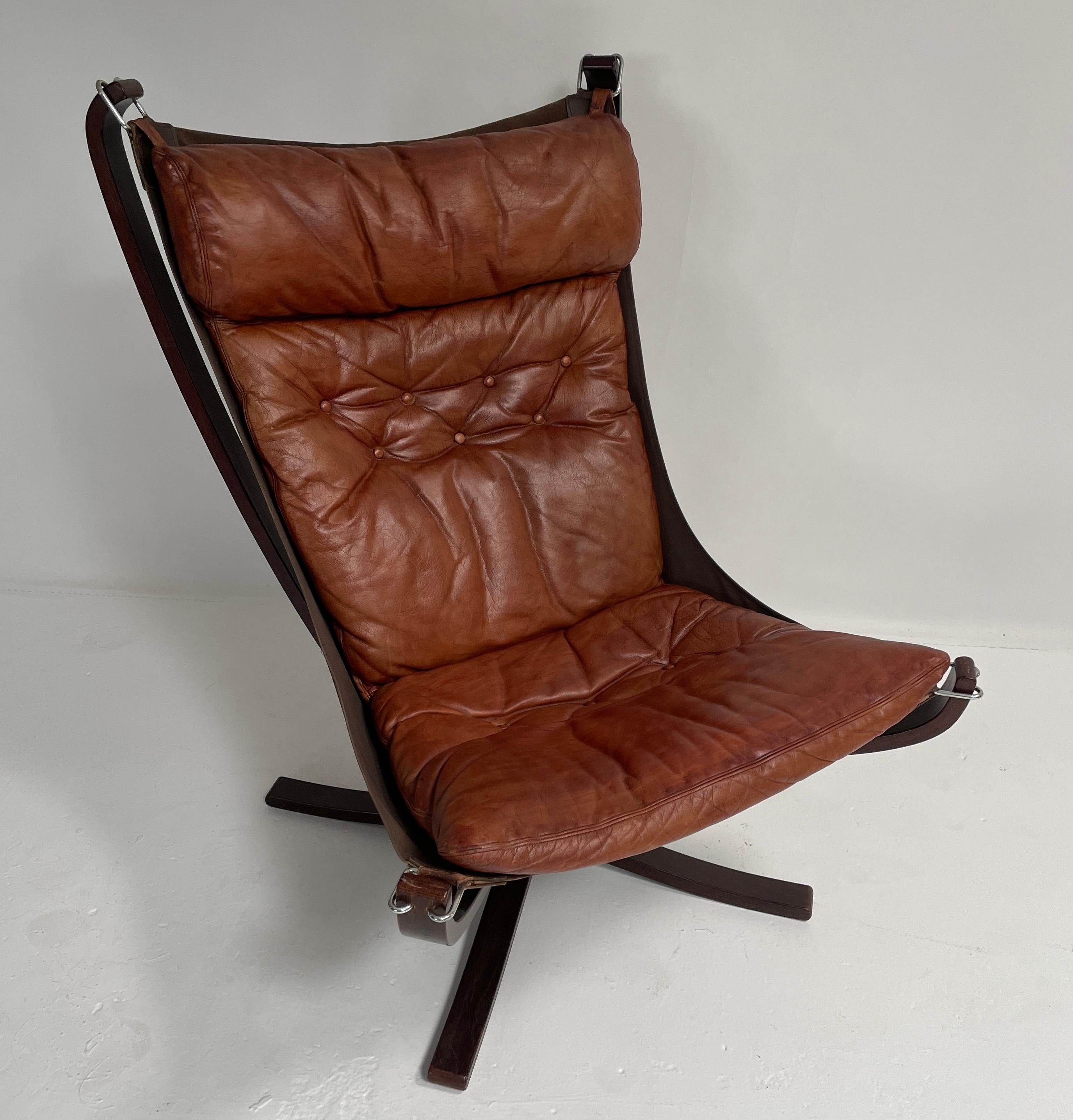 Looking for a vintage chair that will add style and comfort to your living room? Look no further than the Falcon Chair and Ottoman by Sigurd Ressell, a signature piece of iconic Norwegian design. This chair features a leather seat and backrest,