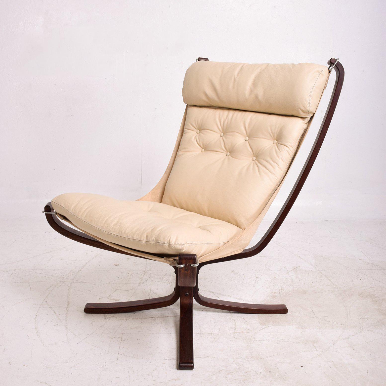 For your consideration a vintage Falcon lounge chair by Westnofa.
Norway circa 1960s. Bentwood legs in sculptural shape in dark rosewood stain. (Original). Canvas has aged sun fade. New leather cushion in ivory color. 

Measures: 38 3/8