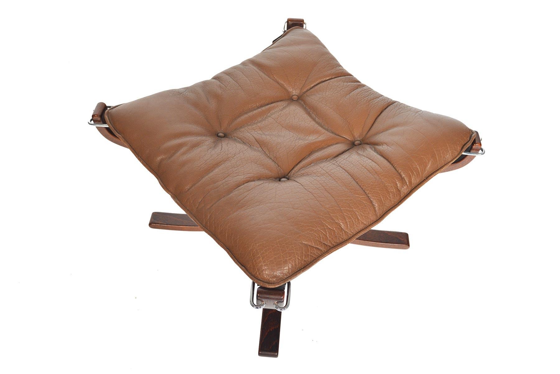 Cette rare chaise ottomane Falcon moderne norvégienne a été conçue par Sigurd Ressell pour Vatne au début des années 1970. Le coussin libre est recouvert d'un cuir patiné de couleur châtaigne d'origine et maintenu dans une écharpe en toile. En
