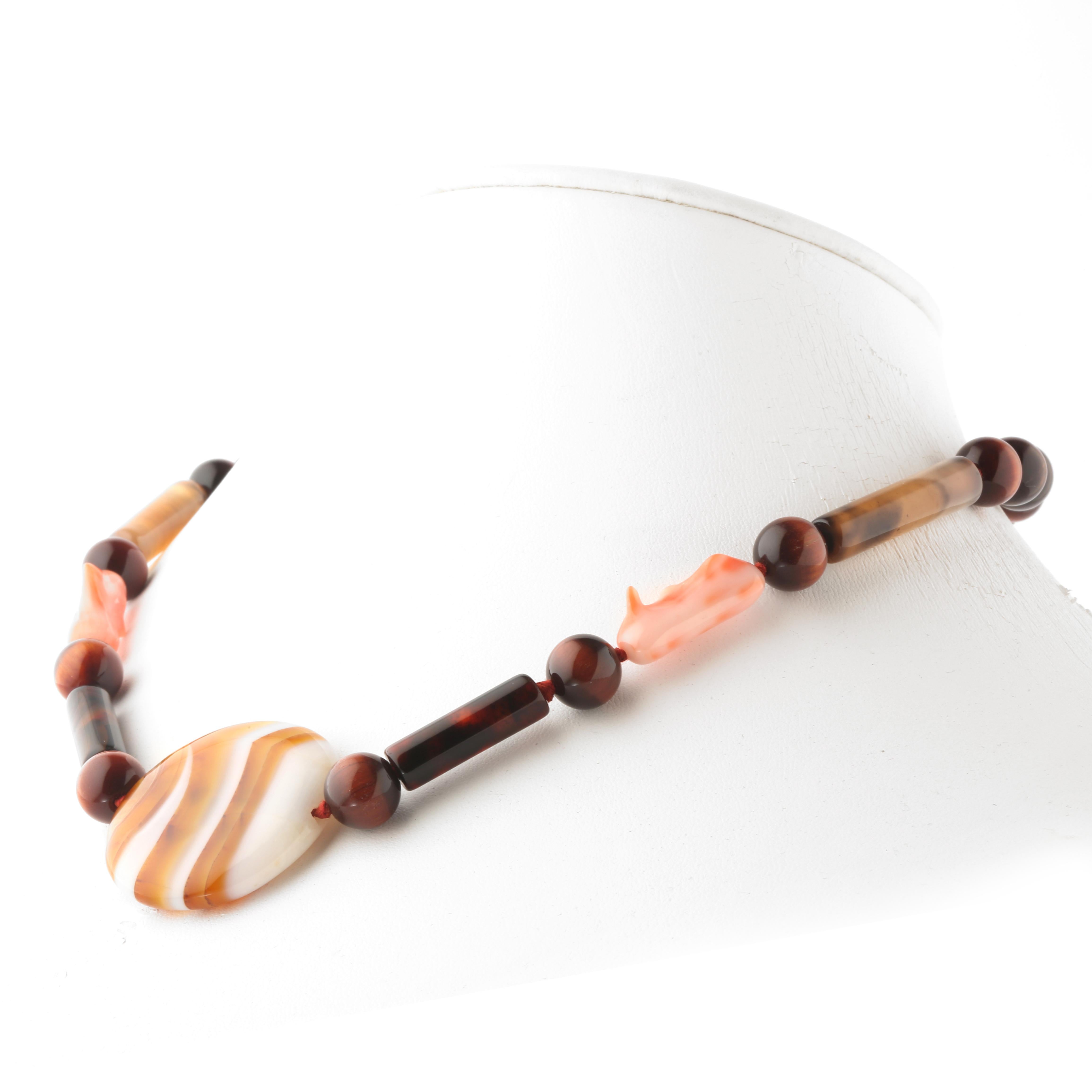 Collana di ispirazione autunnale con perline di materiali preziosi naturali. Immergiti nella bellezza di questa collana dal design unico con pietre naturali piene di vita e di colore. 

Collana con occhio di falco, corallo naturale e agata centrale.