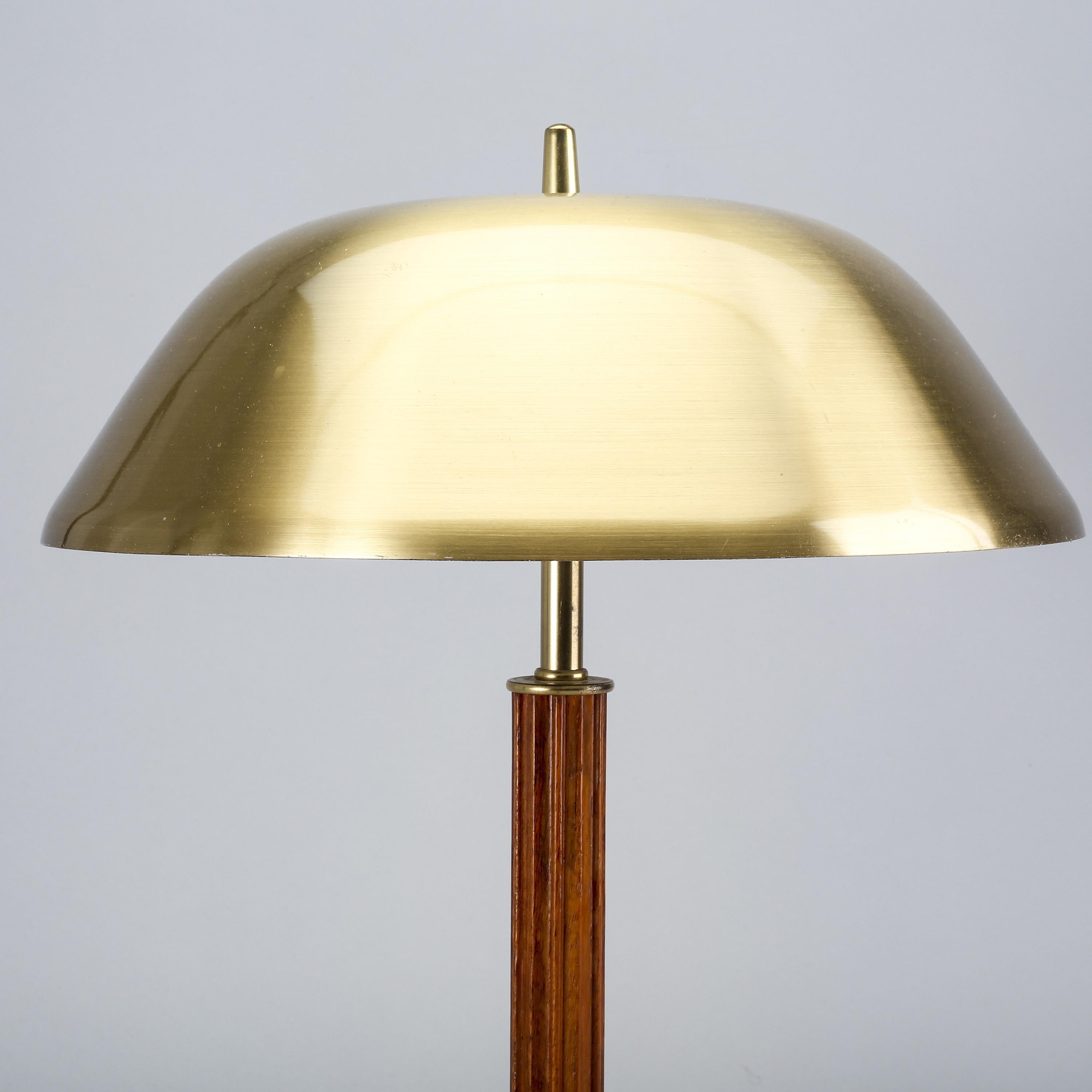 Mid century brass and teak table lamp manufactured by Falkenbergs Belysning in Sweden in the 50's. It has the original wiring that works. We use a European adaptor plug but can be easily changed to adapt to any electrical system.
     