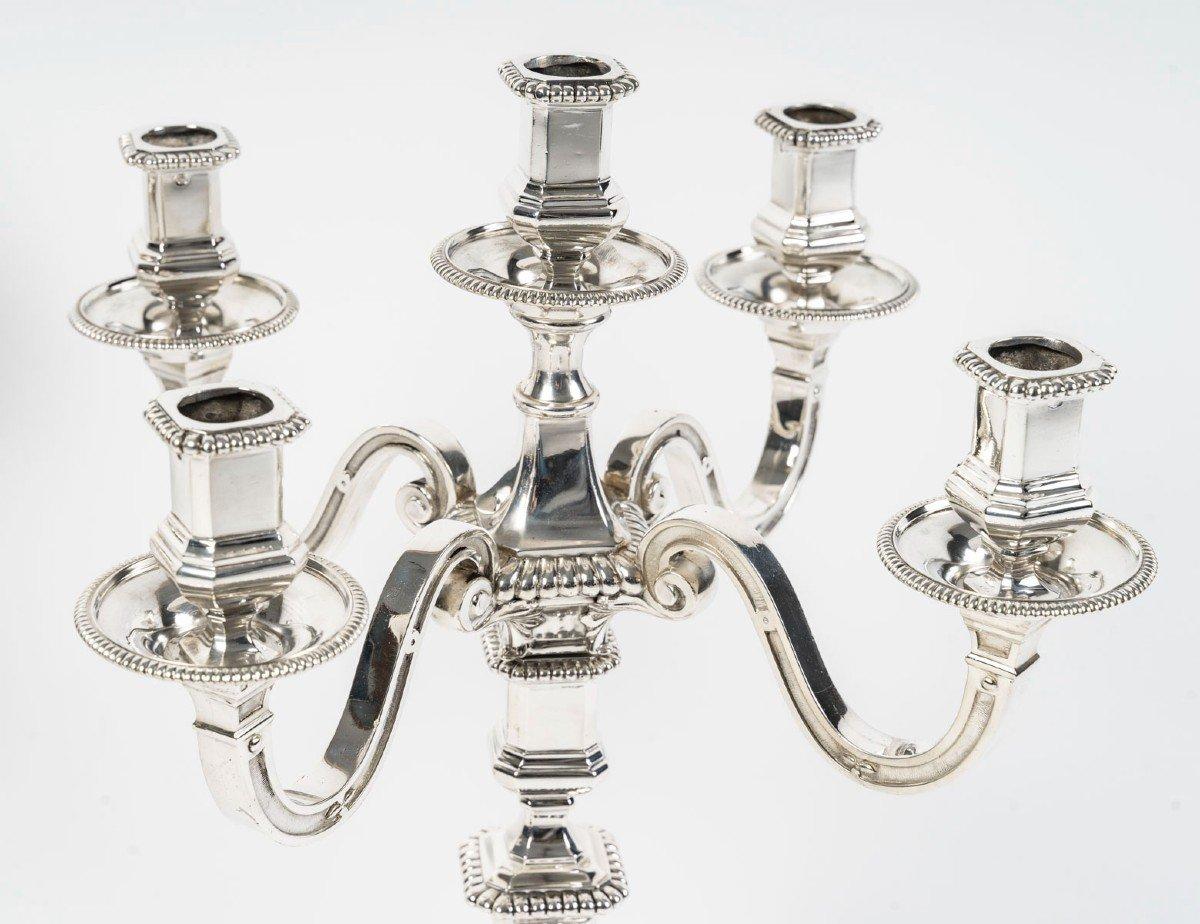 Large pair of solid silver candelabra. The octagonal base decorated with gadroons is surmounted by a shaft on which emerges a bouquet with four arms of light plus a central light, binet cups and shaft decorated with gadroons.

Dimensions: height 45