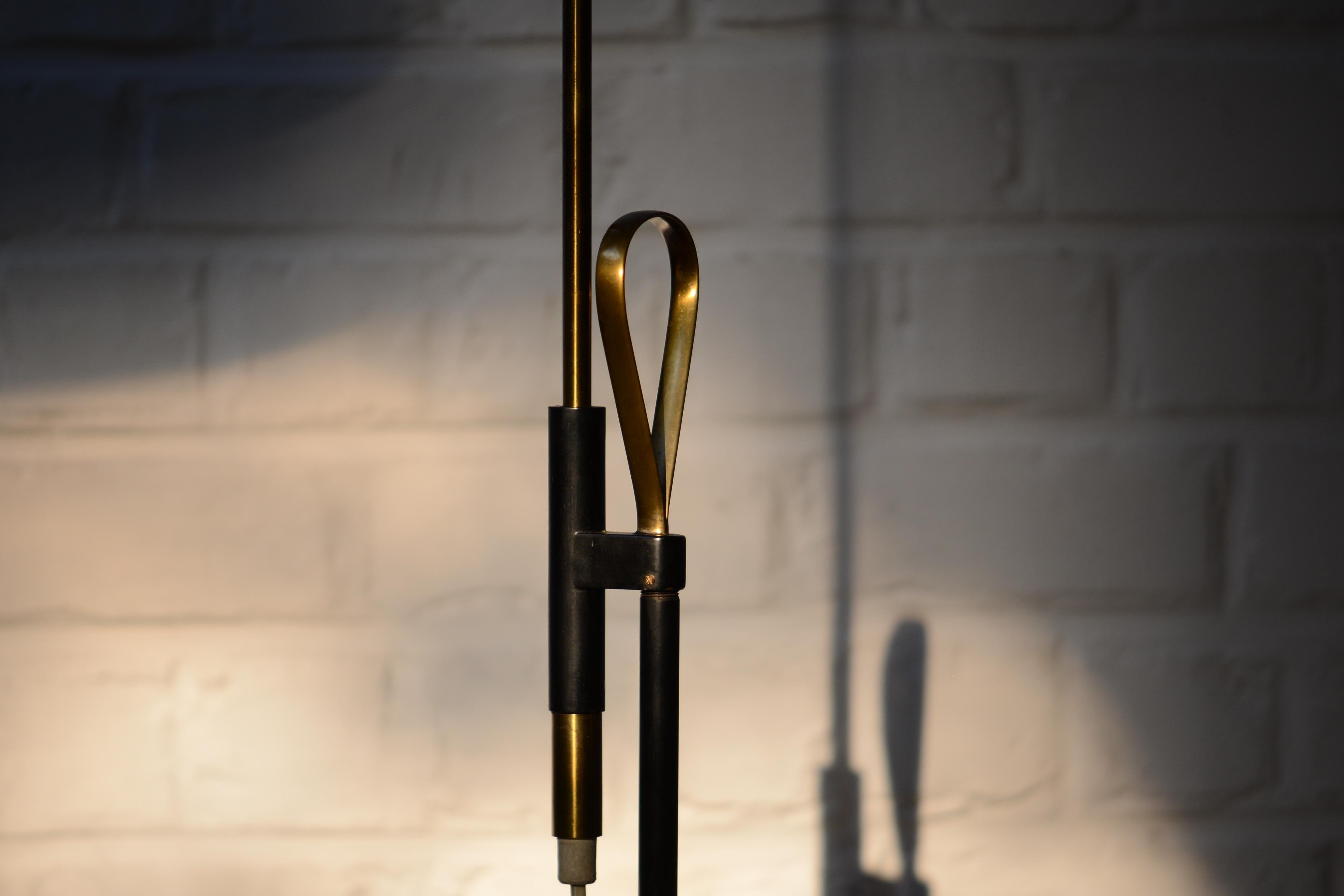 Pair of brass adjustable floor lamps by Falkenberg. The shades are aluminum in white lacquered with a bakelite button. One bubble light inside. You can adjust the inclination of the shade and the height from 95 cm to 145cm. Lots of very nice brass