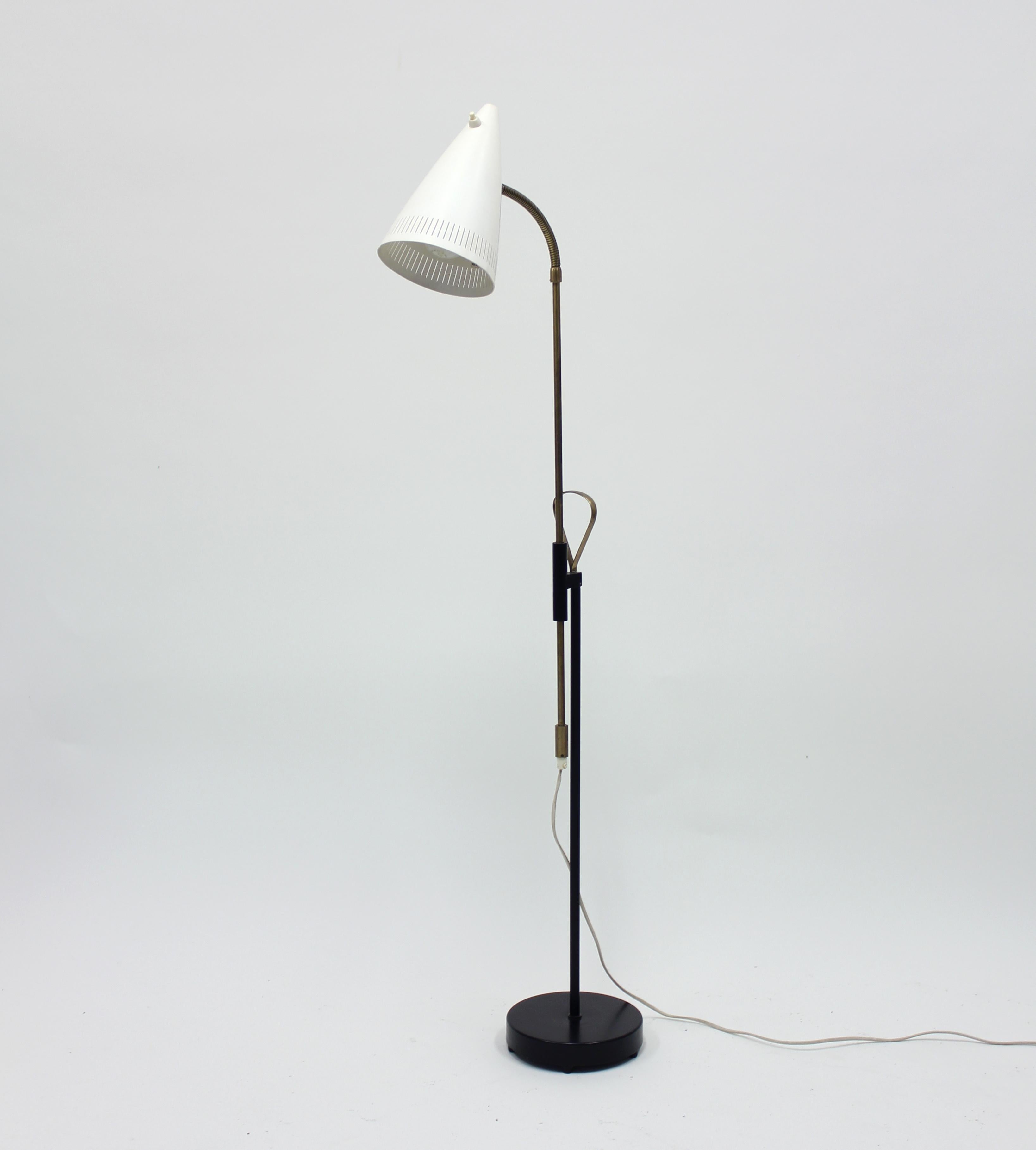 Midcentury floor lamp from Swedish manufacturer Falkenbergs belysning. Height adjustable between 136 - 186 cm. Iron base with a brass stem and original white sheet metal shade. Marked with makers mark under the base. Good vintage condition.