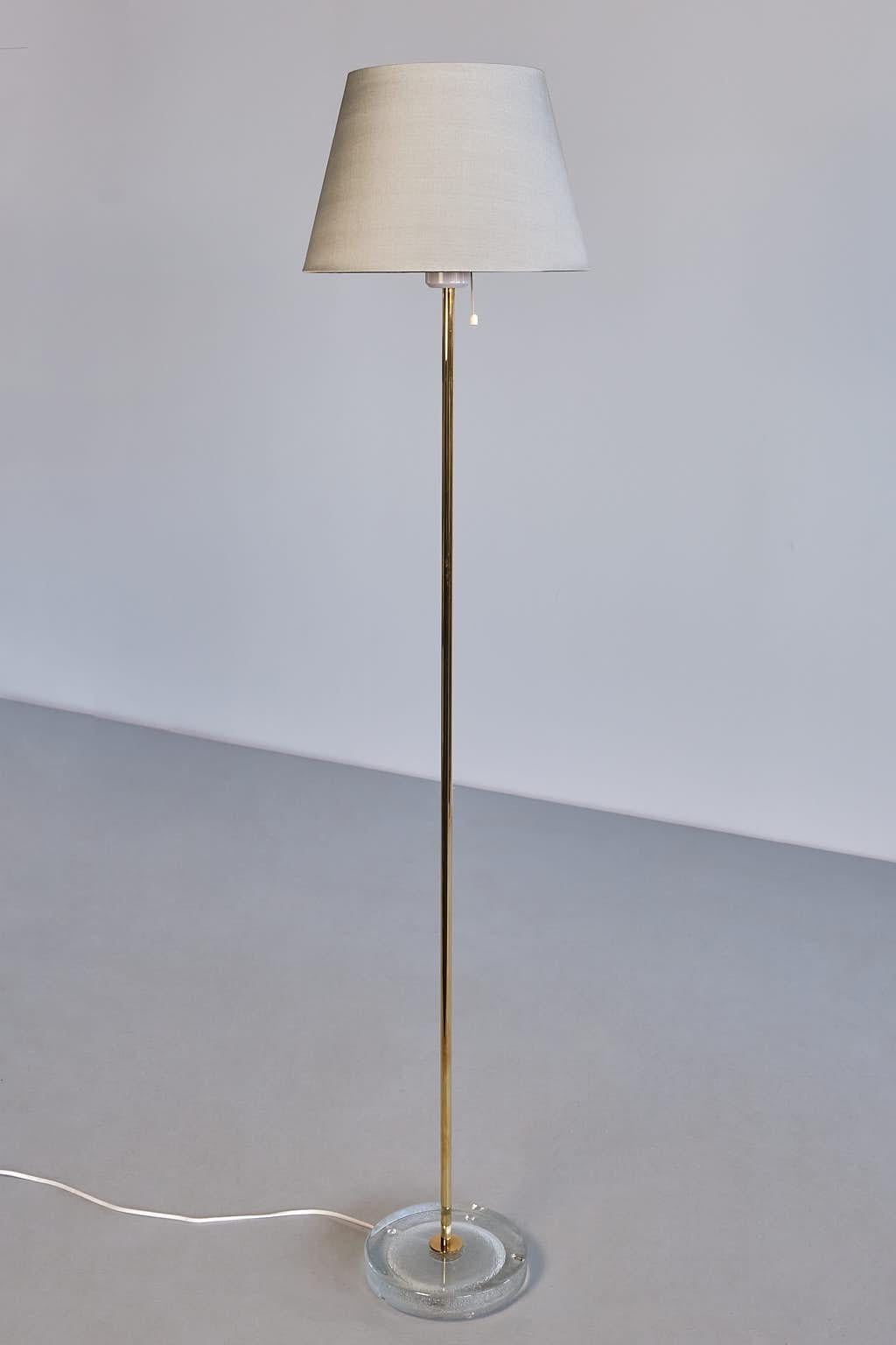 This elegant floor lamp was produced by Falkenbergs Belysning in Sweden in the 1960s. The lamp is marked with the manufacturer's sticker on the inside of the lamp fitting.
The design is composed of a slightly raised, circular foot in textured glass.