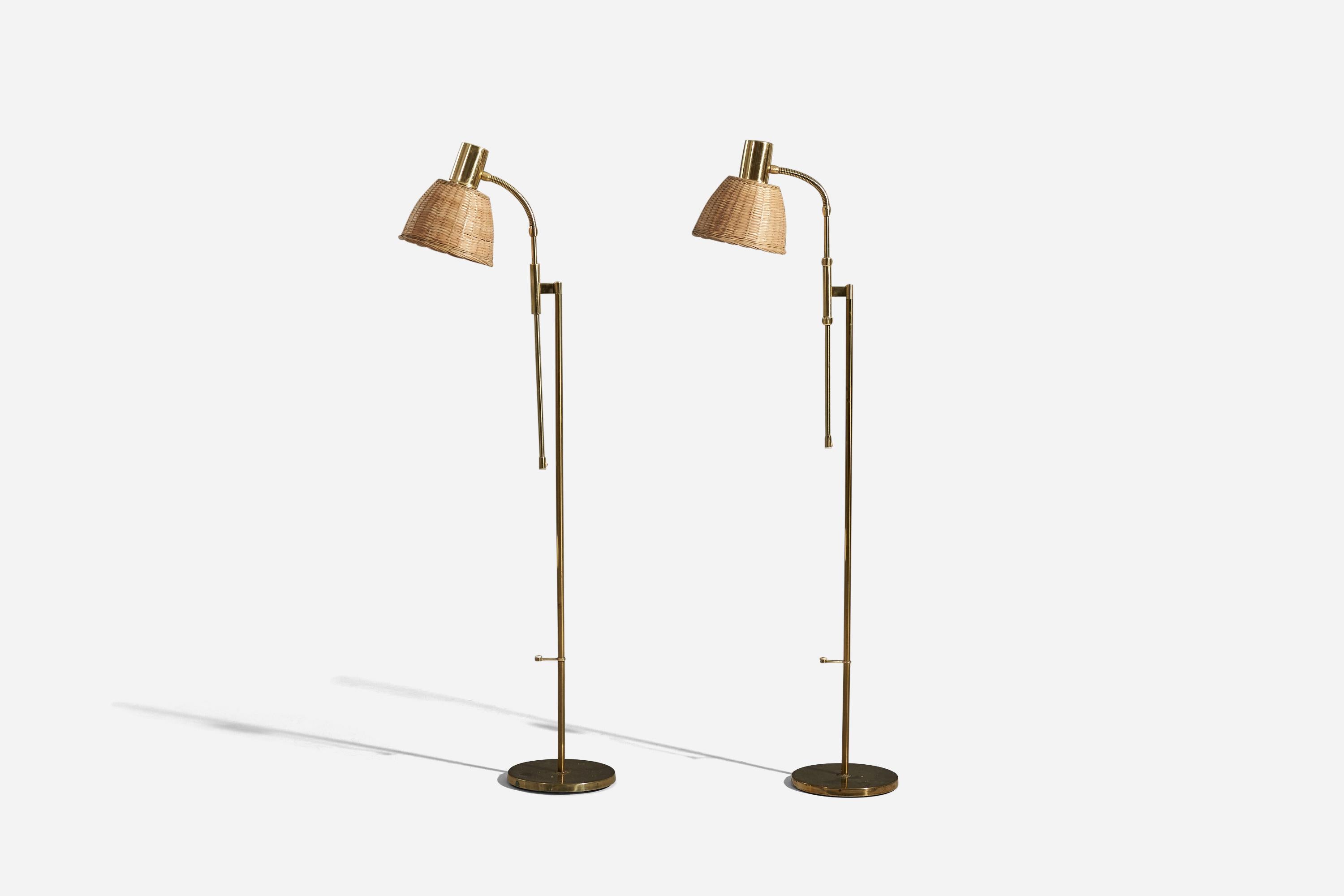 A pair of adjustable brass and rattan floor lamps designed and produced by Falkenbergs Belysning, Sweden, c. 1970s.
  