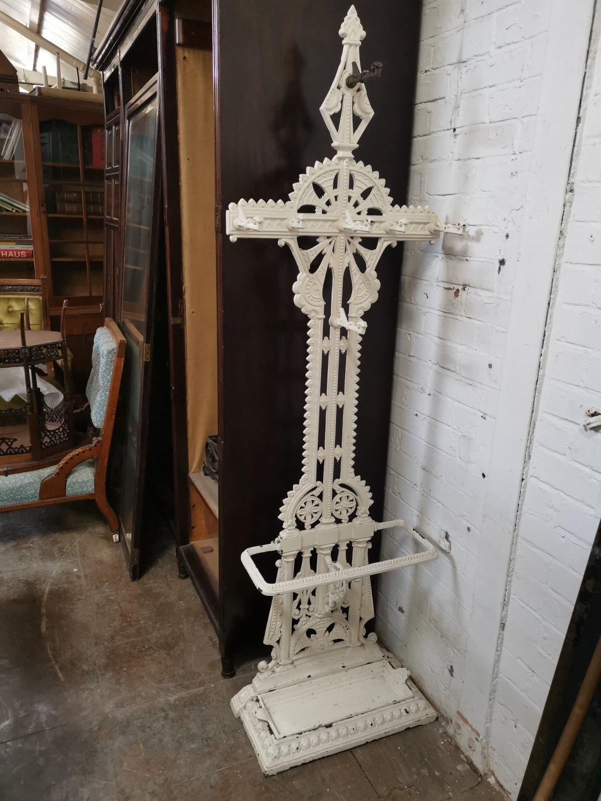 Falkirk iron Foundry. In the style of Dr C Dresser.
An Aesthetic Movement painted cast iron hall stand, the upper part with six hooks above a stick stand with removable tray, lozenge kite registration stamp to reverse.
One coat hook is painted