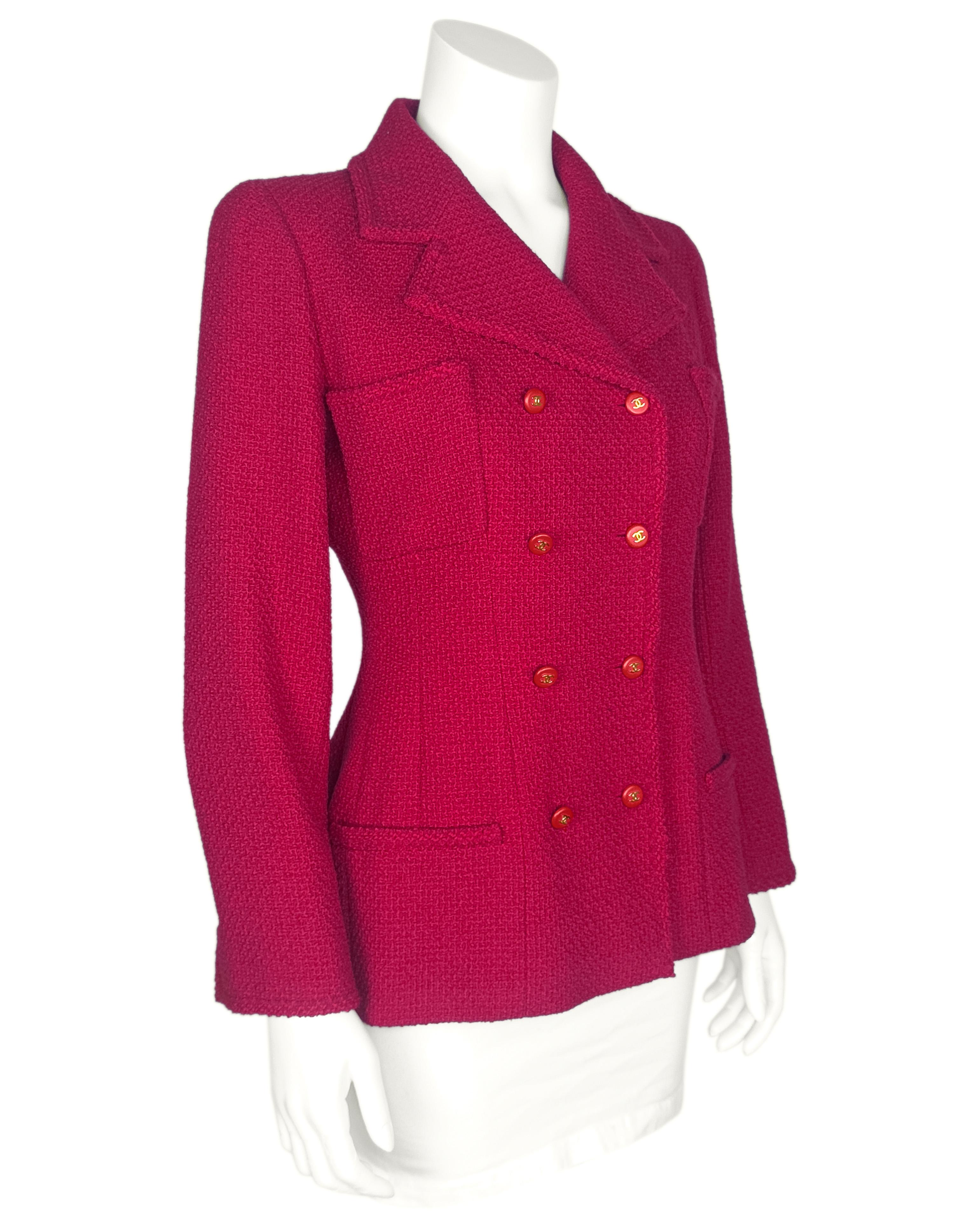 Zeitlose Chanel-Jacke aus der Herbstkollektion 1995. Gefertigt aus einem Wollboucle in einer fabelhaften Mischung aus klassischem Chanel-Rot und -Magenta. Zweireihig mit kleinen roten runden Kunststoffknöpfen mit goldfarbenen cc-Logos. Zwei