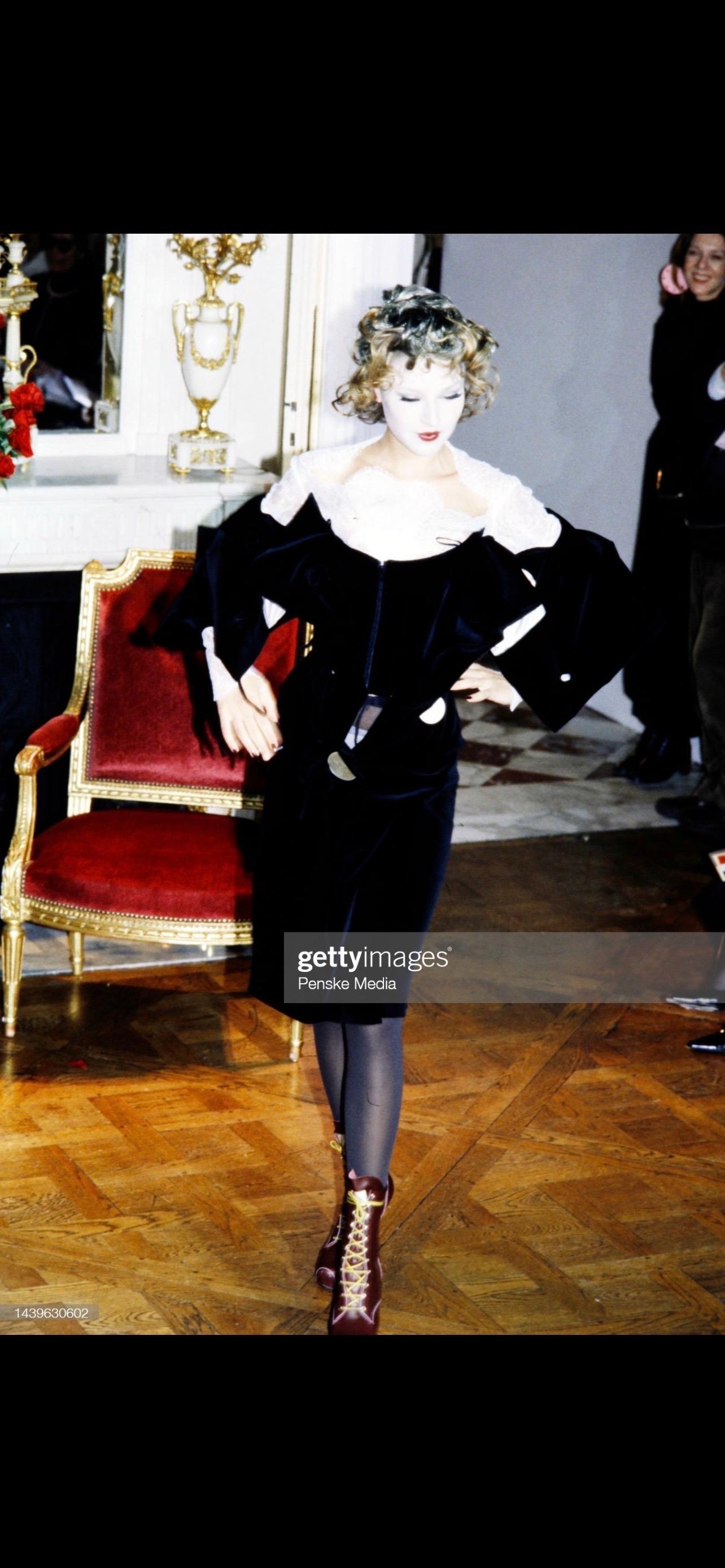 An absolutely incredible dress from Fall 1998 collection, made out of signature for Vivienne Westwood black velvet. The dress has an integrated corset, which can be hidden or showed by opening the dress with just one large orb-stamped button. The