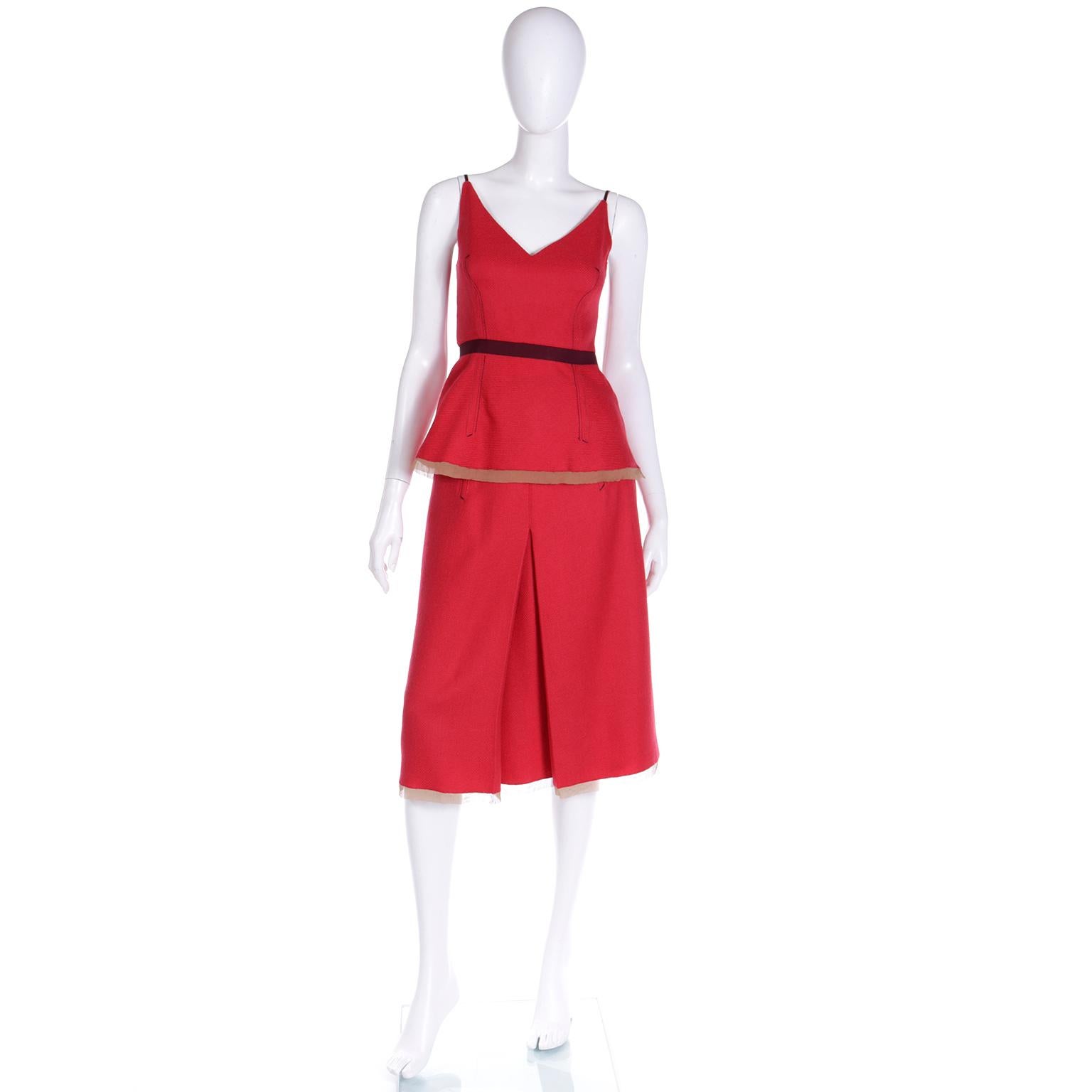 This fabulous Prada Fall Winter 2000 red wool 2 piece dress includes a V neck sleeveless top and an A line skirt. Both pieces have princess seams and soft gold raw silk trim at the hemline. The top also has a purple band to define the waistline.The