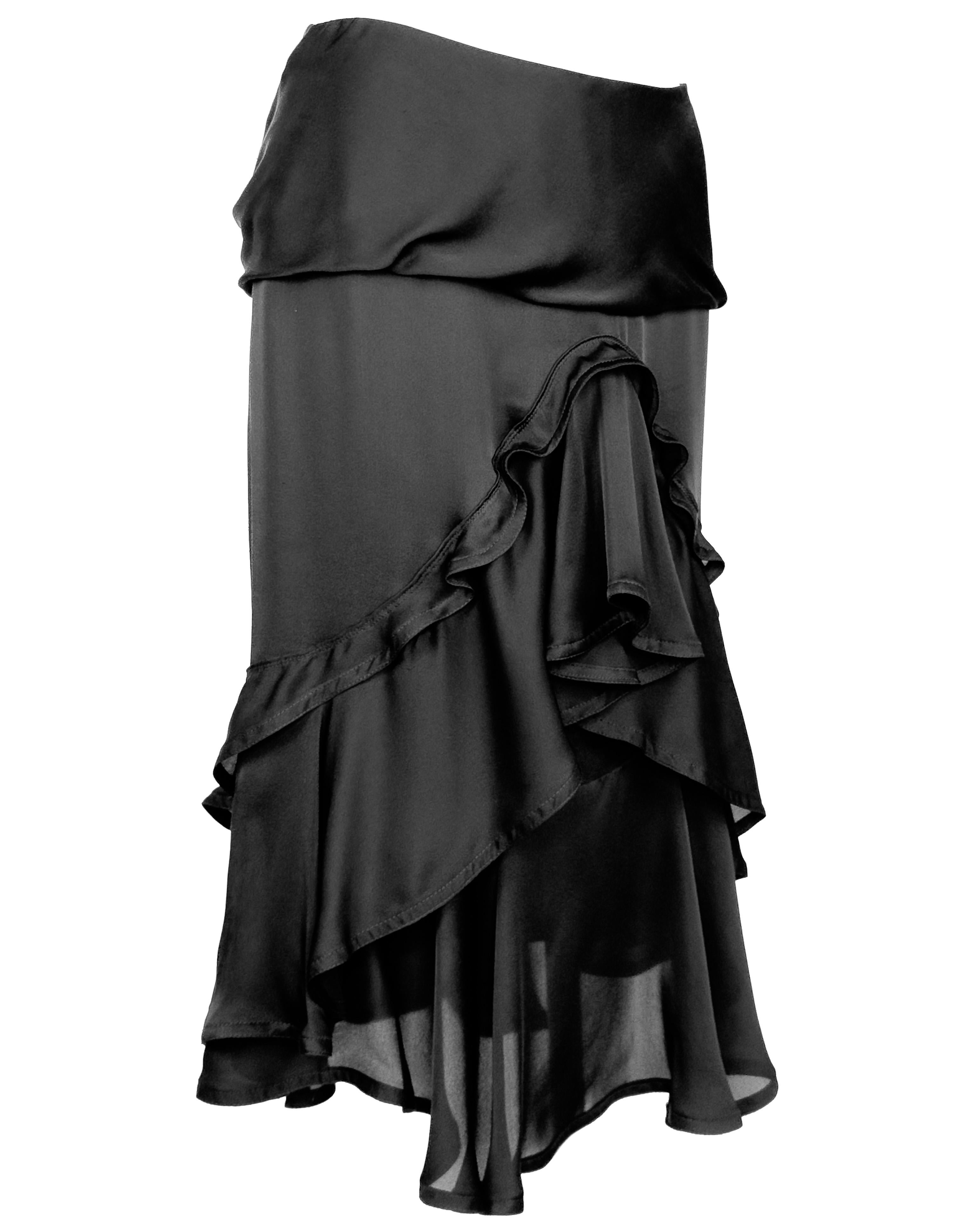 Captivating skirt from Tom Ford’s Fall 2002 collection for Yves Saint Laurent. Crafted from a black fluid silk satin, the skirt features an exaggerated flounce at the front, cascading into asymmetric layers of ruffles that evoke the movement of
