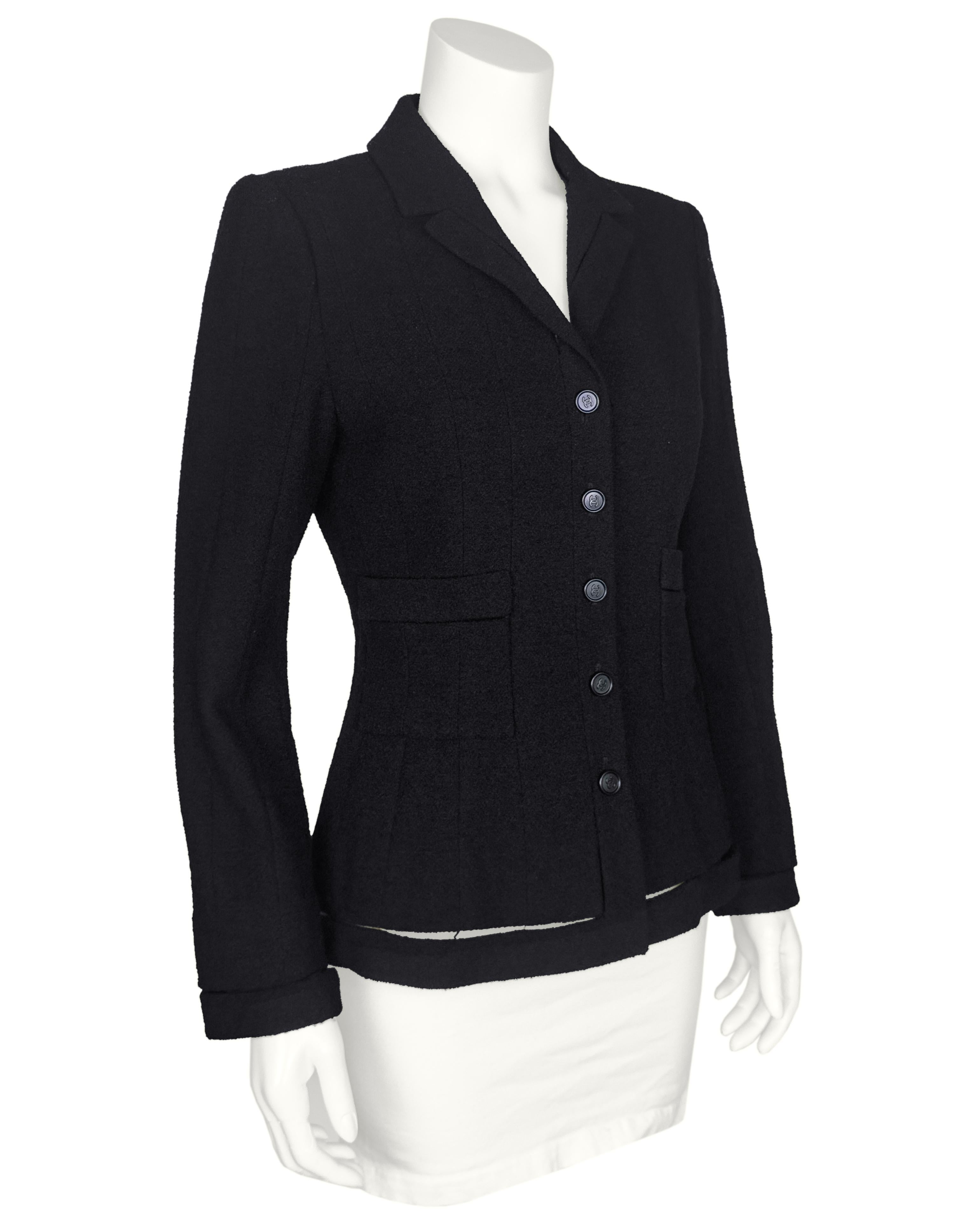 Un tocco unico su una classica giacca Chanel con questo pezzo della collezione Autunno 2003. La giacca è un classico blazer aderente in stile equestre con  un colletto scollato e cuciture lusinghiere su tutto il corpo. L'orlo, i polsini e la parte