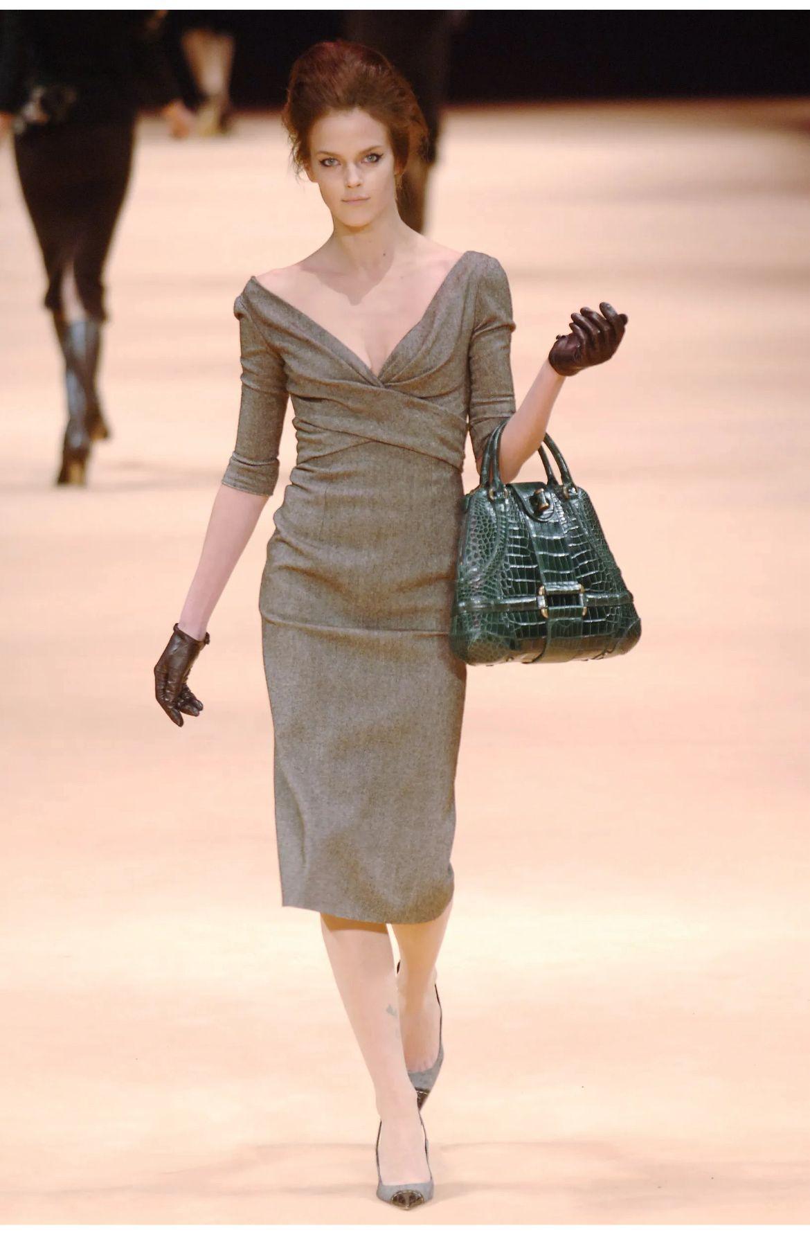 Schickes Herbst-/Winterkleid 2005 von Alexander McQueen aus braunem und cremefarbenem Tweed mit 3/4-Ärmeln, drapiertem V-Ausschnitt, verdecktem Reißverschluss am Rücken und knielangem Saum. 
Ähnlich wie die Silhouetten der 1950er Jahre ist das Kleid