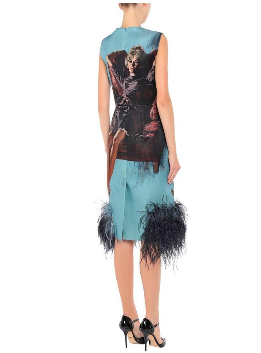 PRADA

Pale blue and multi-color Prada wool and silk-blend sleeveless midi dress (2017 Collection) with poster girl print throughout, 
Round neckline, feather accents at hem and concealed zip closure at center back.

Size IT 44 - 8

Pre-owned.