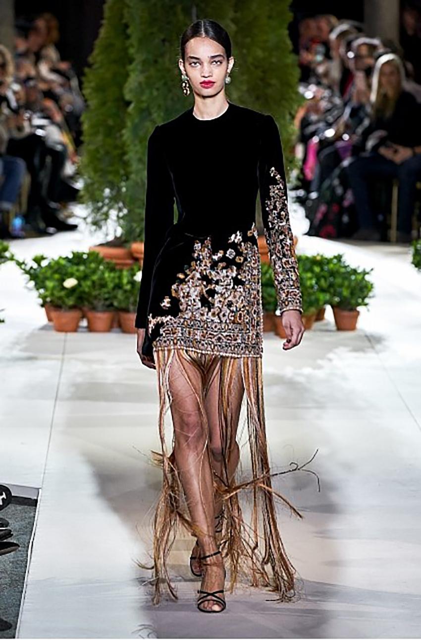 Oscar de la Renta dress is a runway piece, from Fall 2019 Ready-to-Wear collection.

The dress was inspired by Moroccan carpets. 
It is made of supple velvet and embroidered in an asymmetrical degrade design.
The hem is decorated with floor sweeping