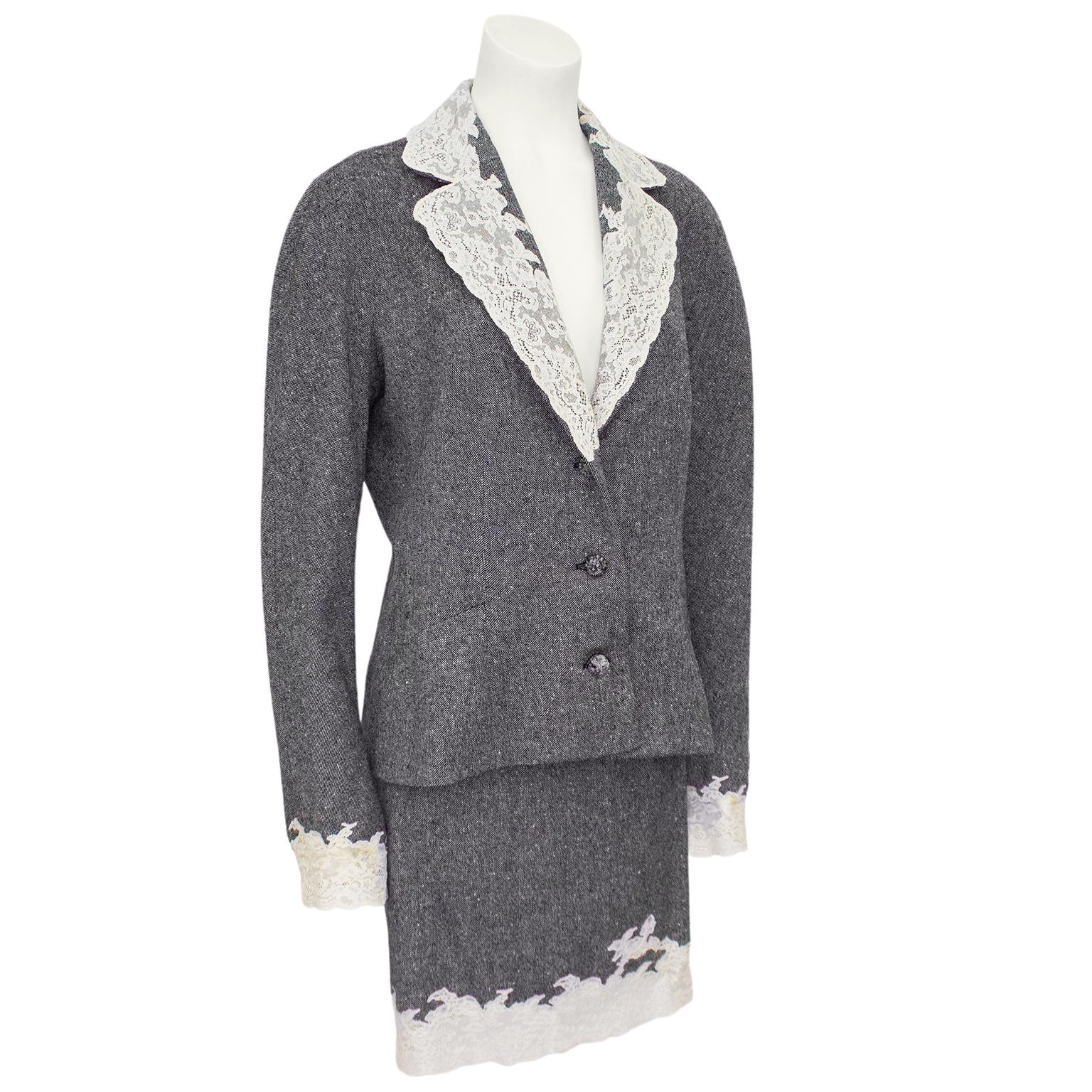 Christian Dior suit from the fall/winter 1998 collection. Grey wool tweed blazer embellished with with cream lace at the notched collar and cuffs. Oversized shoulders and three matching grey passimentarie buttons. Cream silk lining with large