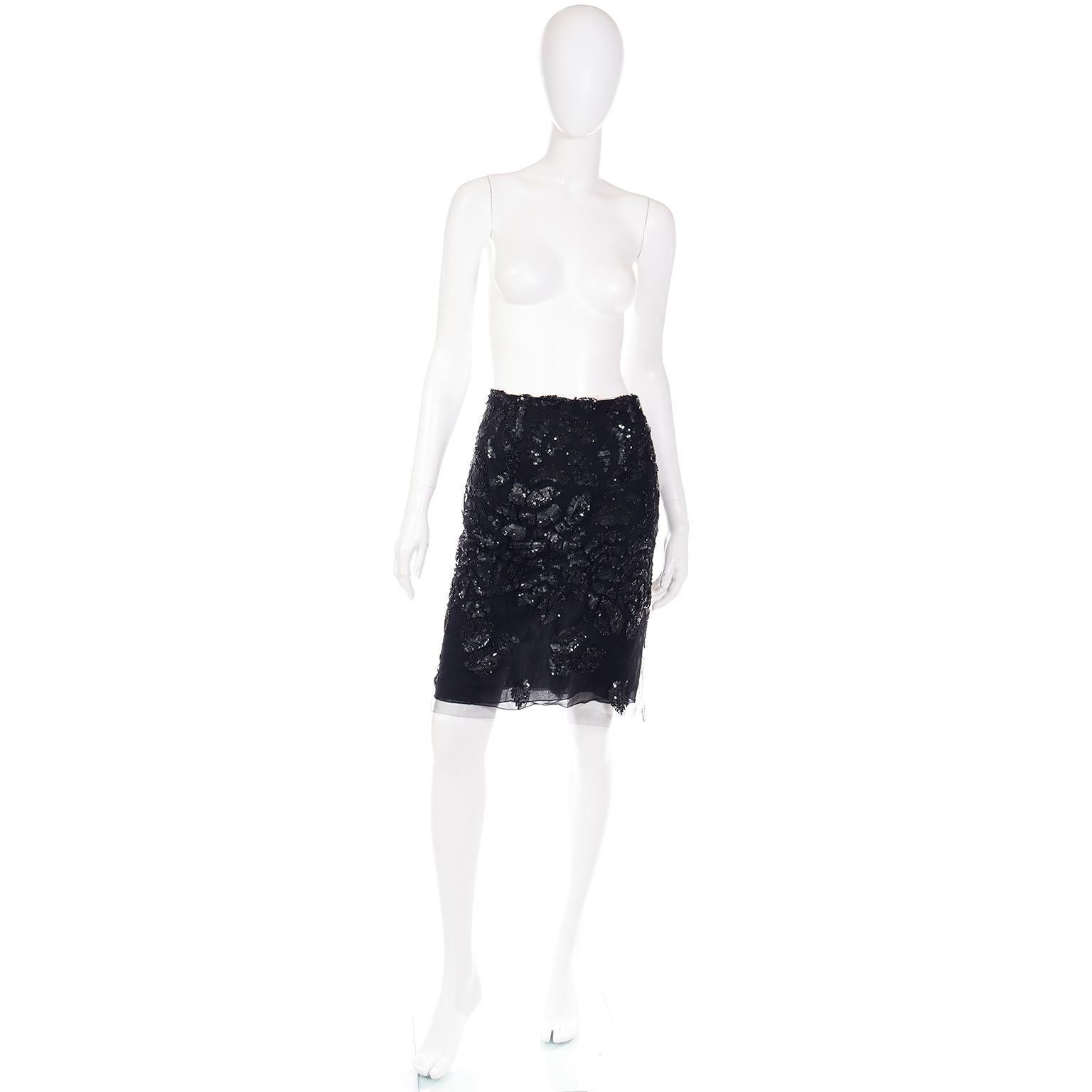 This is an exquisite Fall/Winter 2000 Valentino Garavani black silk skirt with a mesh overlay. This stunning skirt is beautifully embellished with stacked black sequins in the shapes of feathers or leaves. This skirt closes with a left side zipper.